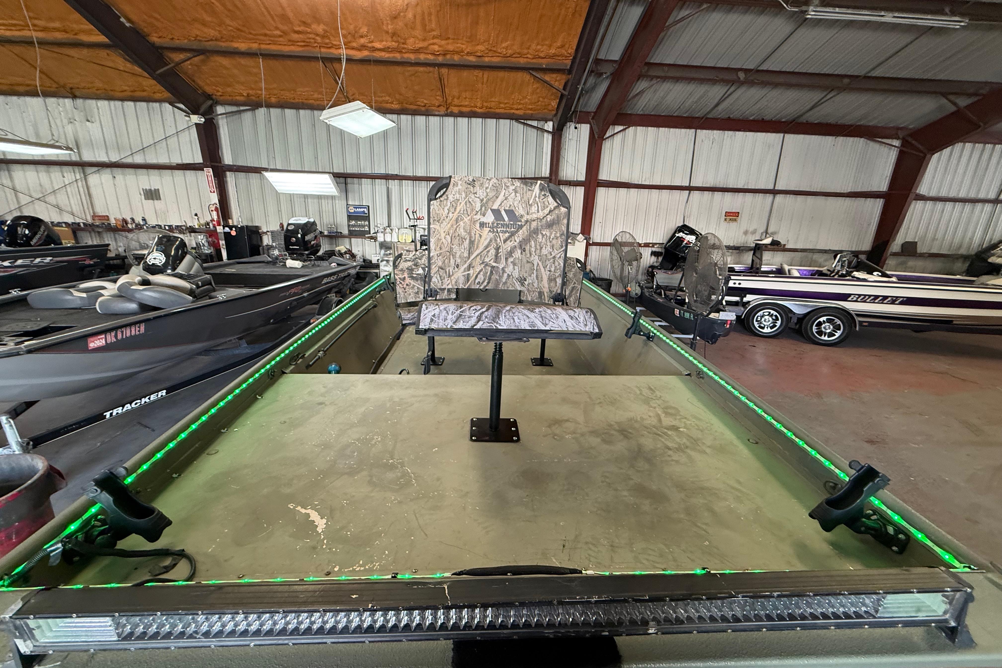2020 Lowe Roughneck 2070 Big River boat in a warehouse, featuring camo seating.