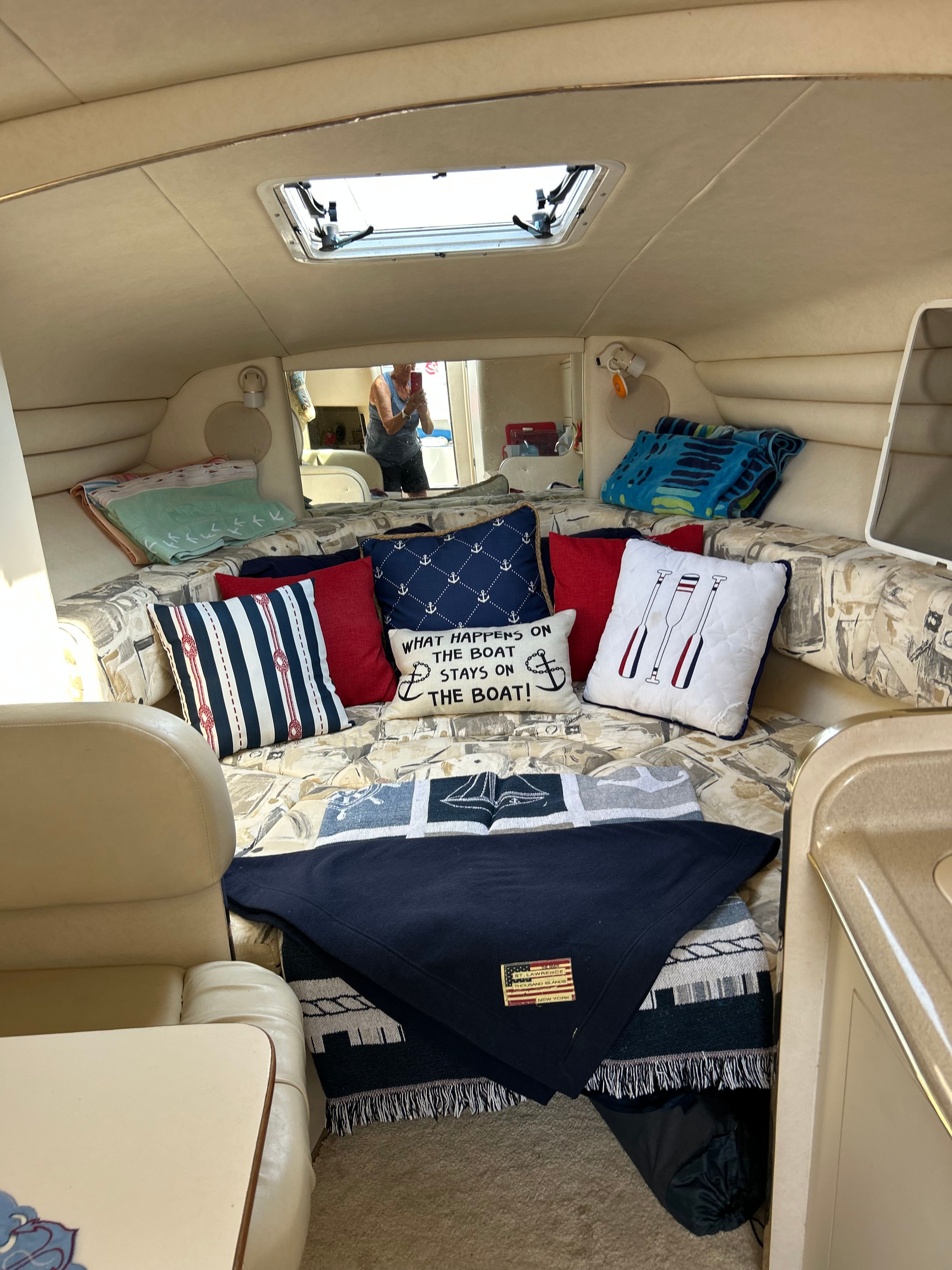 Interior of a 1999 Sea Ray 270 Sundancer Special Edition with cozy pillows and blankets.