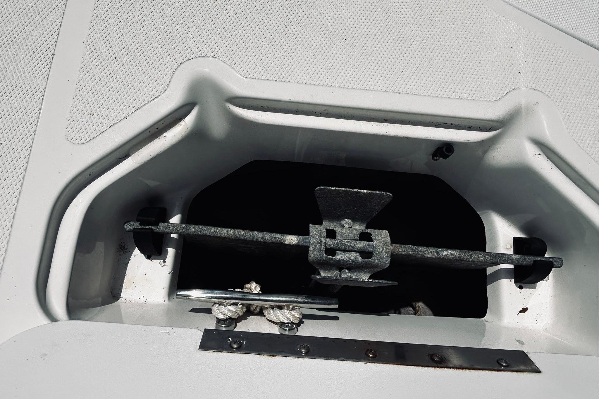 Close-up of an anchor locker on a boat with ropes and anchor.