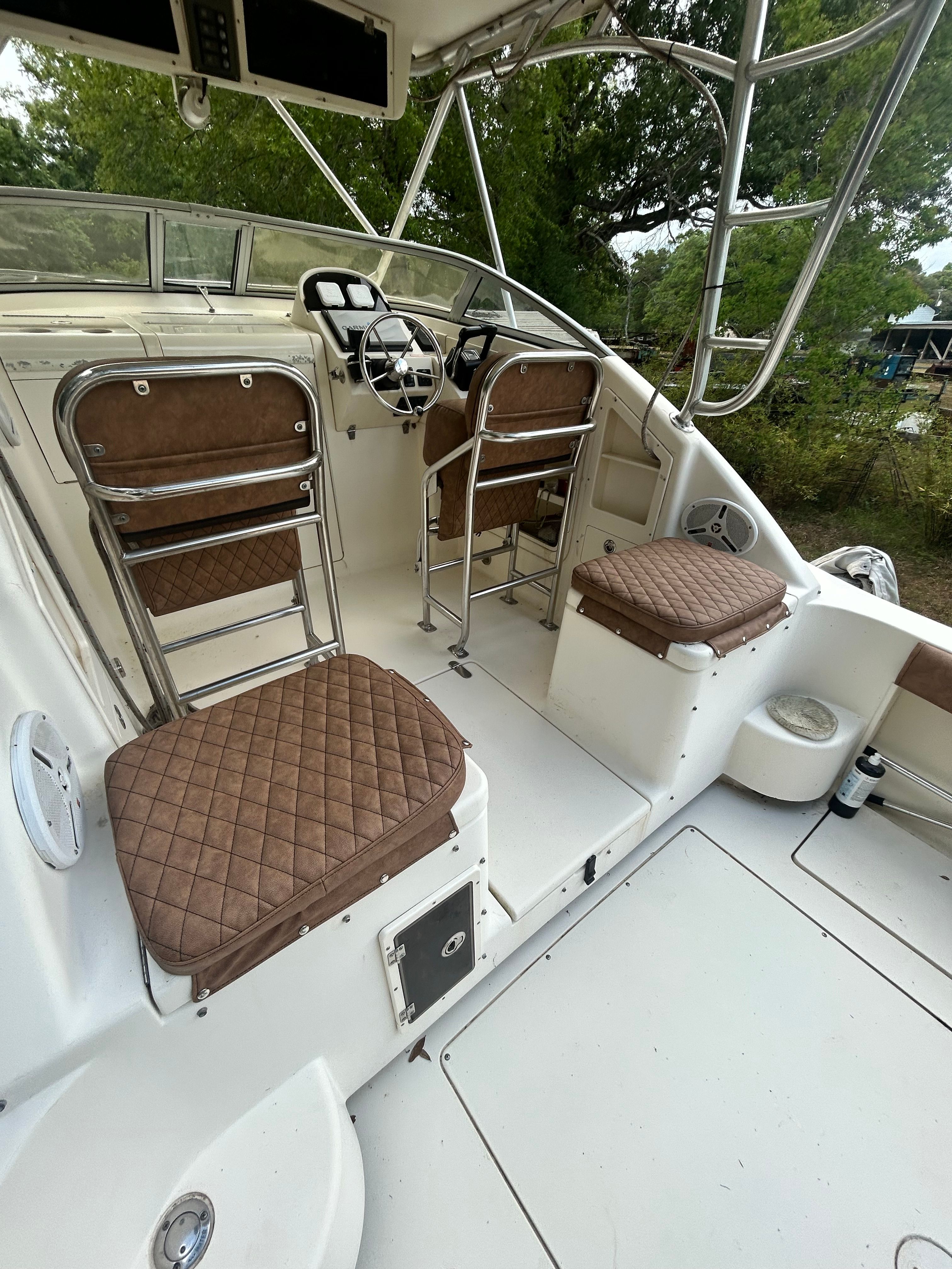 Interior of a 2003 Scout 280 Abaco with brown cushioned seats and a helm station.