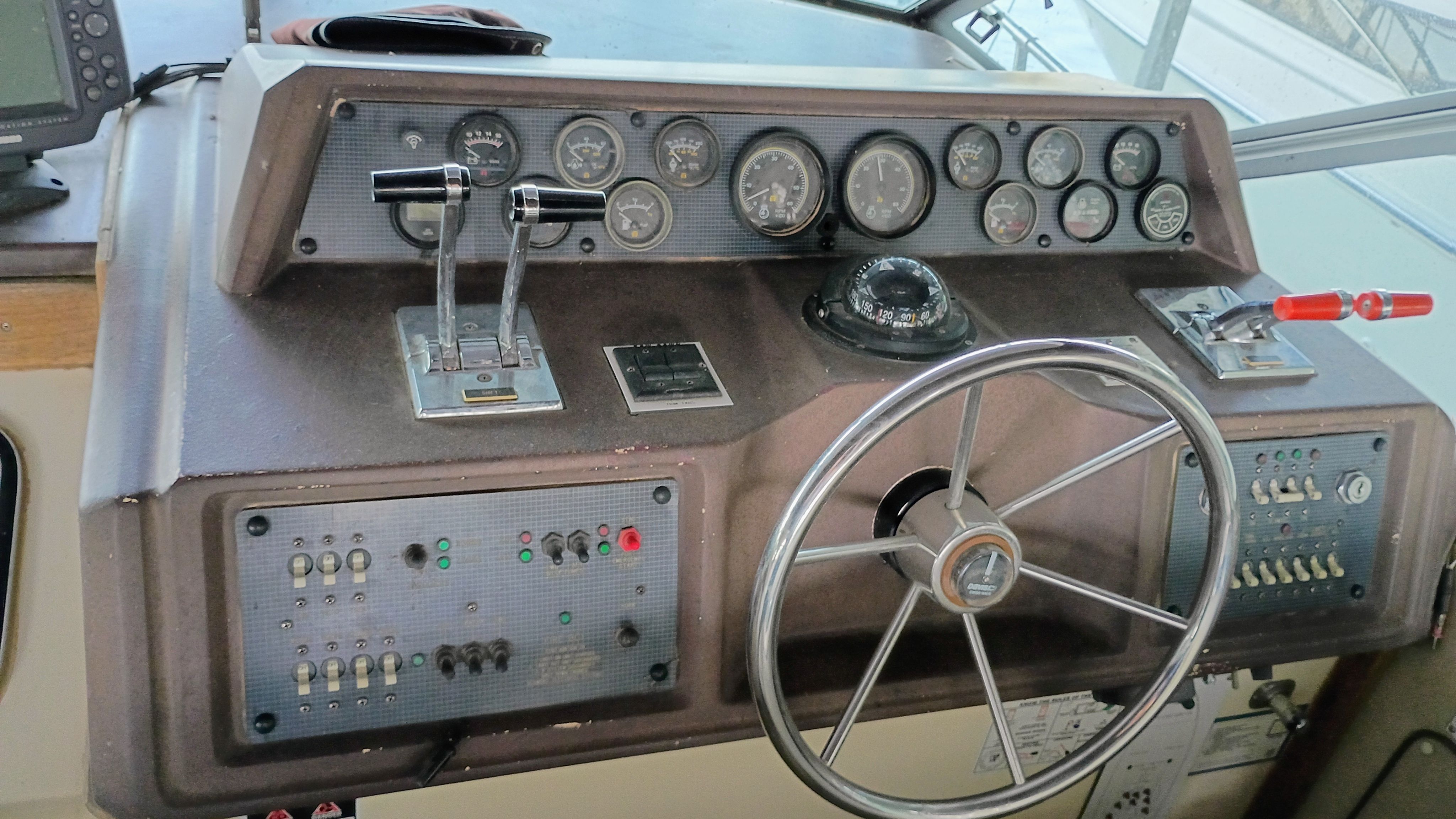 The image shows the helm of a 1986 Sea Ray Sundancer with various gauges and switches.