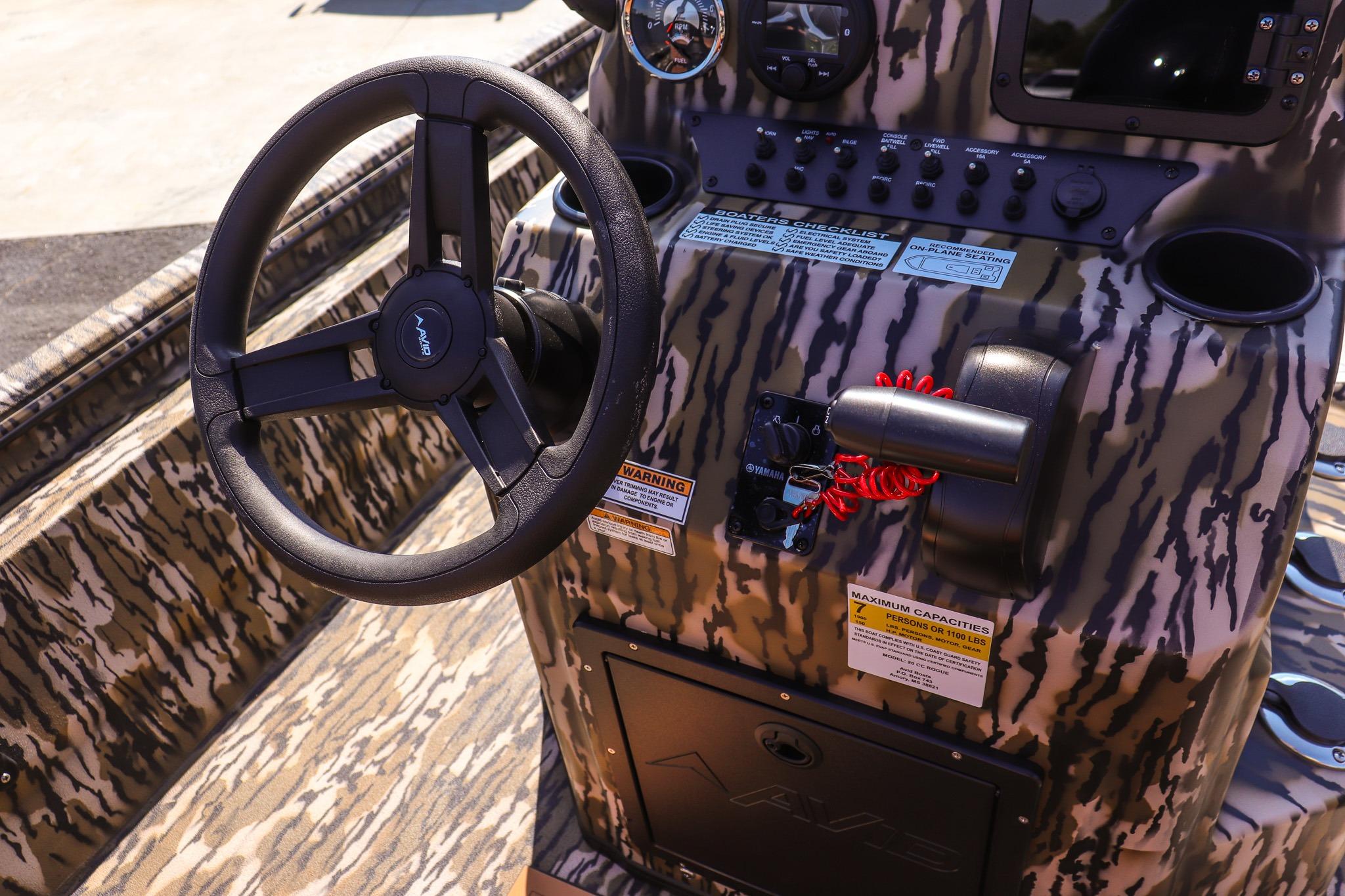 The image shows the cockpit of an Avid 20 Rogue CC boat with a camouflage design.