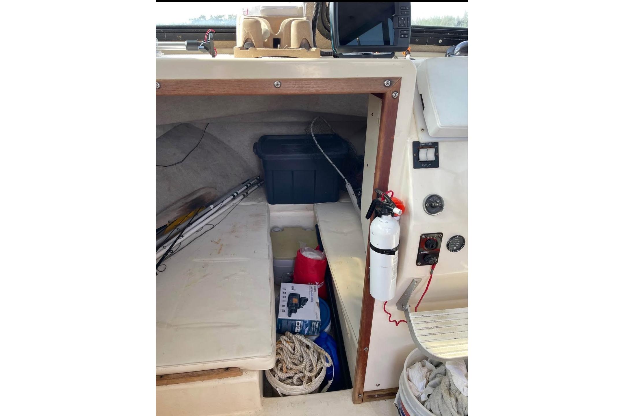 Interior of a 2002 Parker 2520 Deep Vee Sport Cabin with fishing gear and safety equipment.