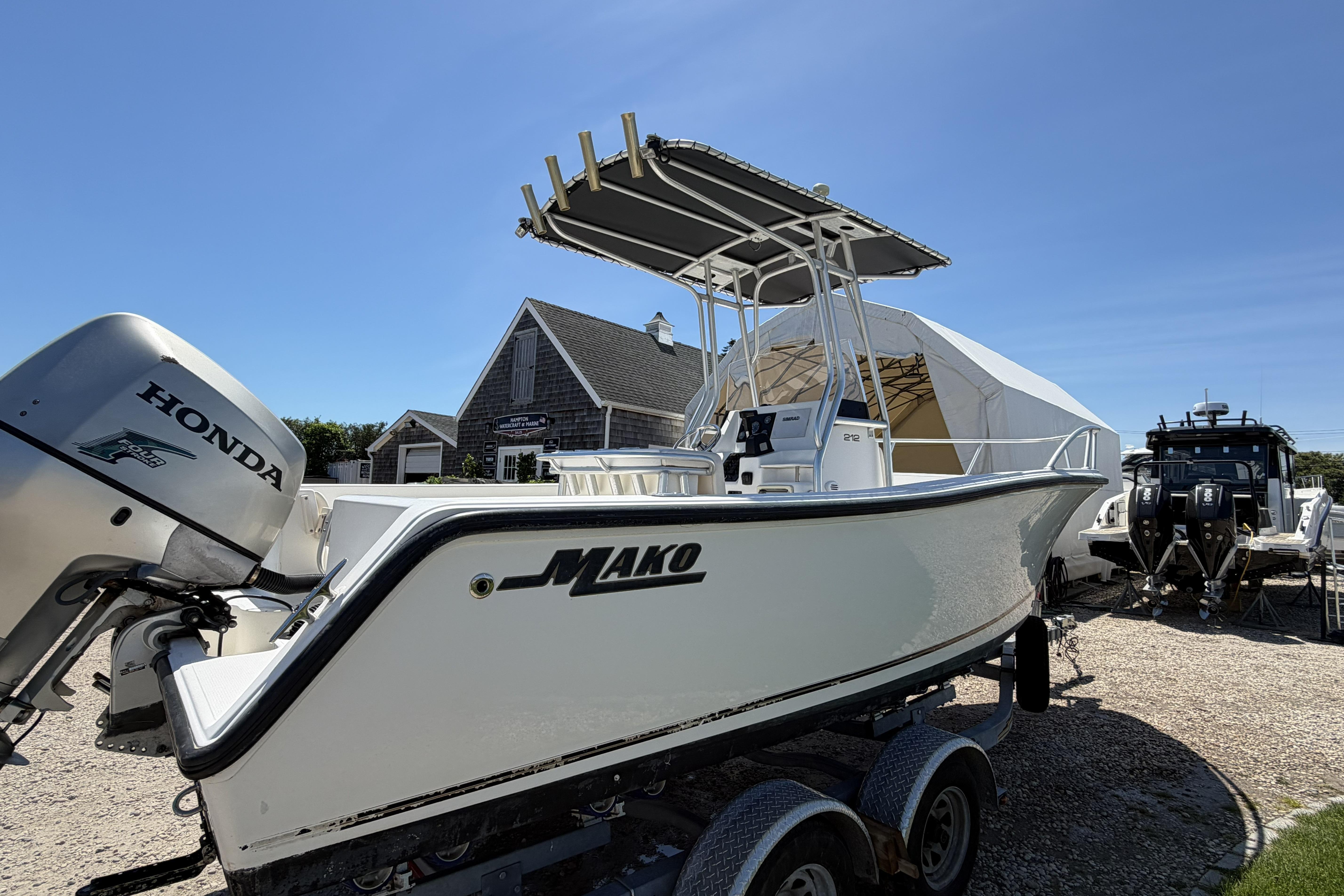 2006 Mako 212 Center Console boat with Honda engine, parked outdoors under clear blue sky.