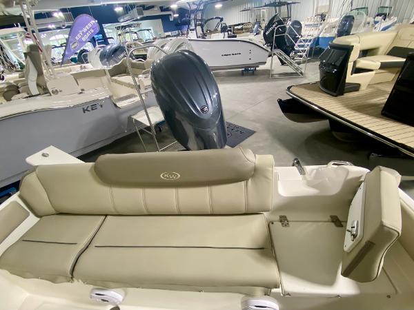 2024 Key West 219 FS boat interior with beige seating and outboard motor.