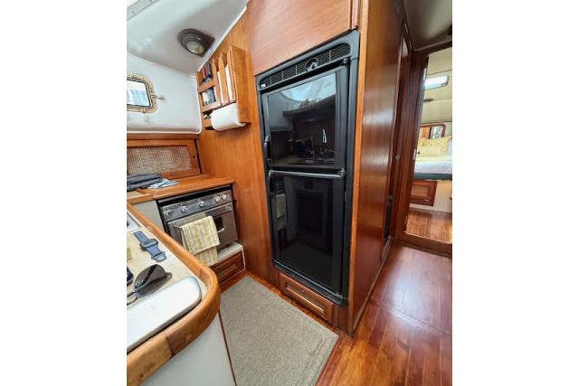 1982 Lancer 45 Motorsailer interior kitchen with wood cabinetry and modern appliances.