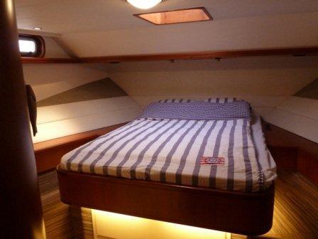 Luxurious cabin interior of 1987 Moonen 72 yacht with striped bedding.