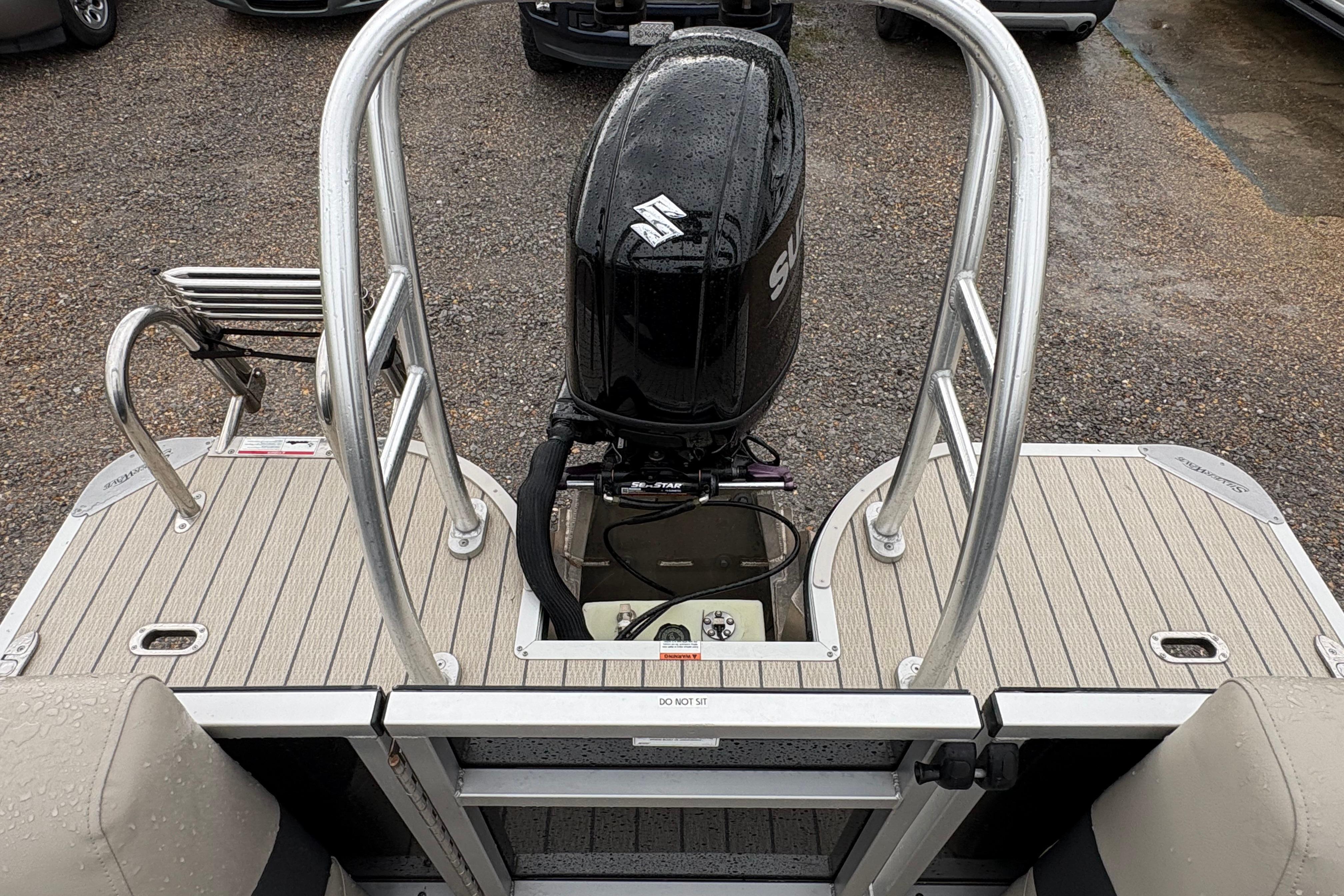 2023 SilverWave 2410 CLS boat with Suzuki outboard motor, rear view on wet deck.