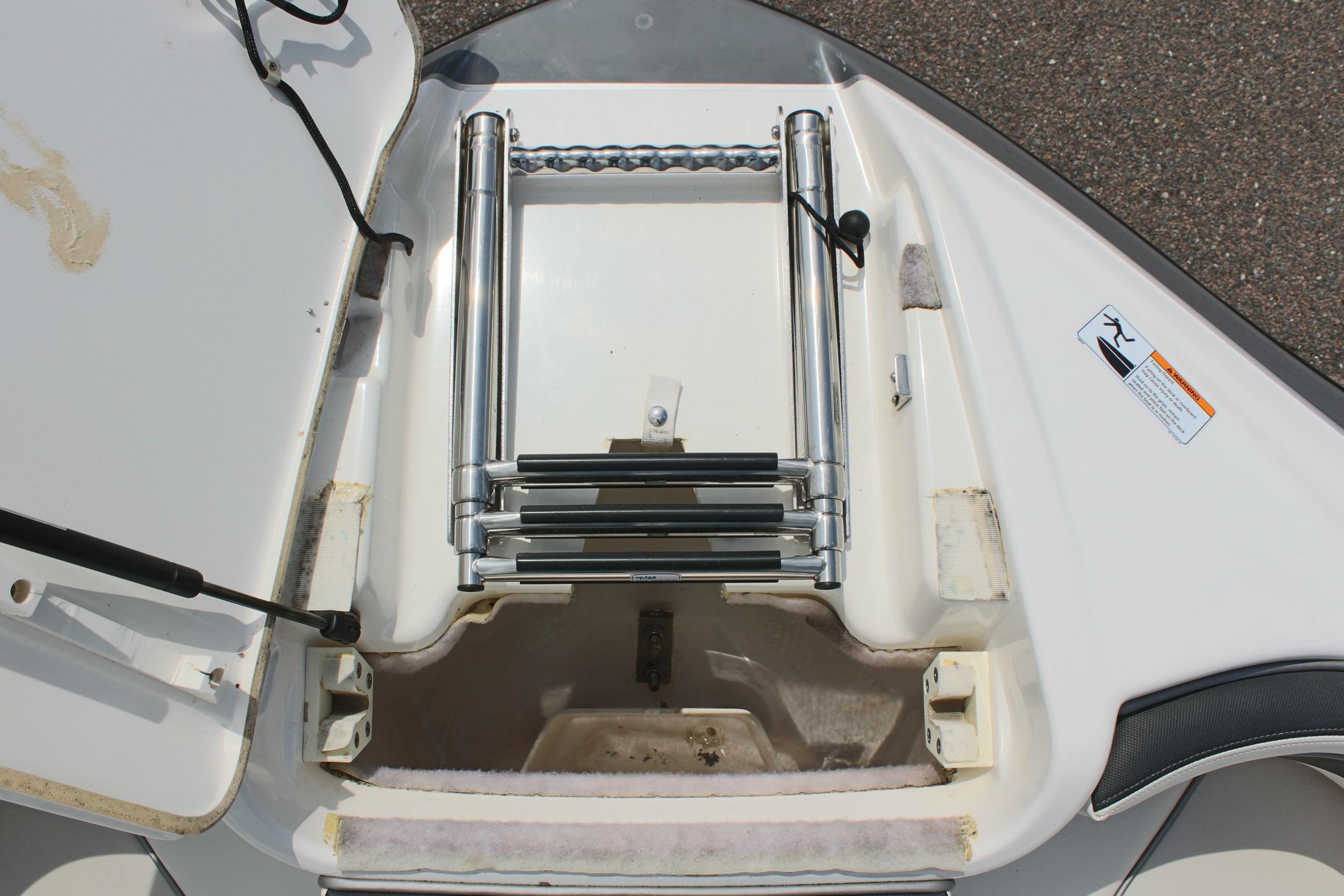 2016 Yamaha Boats 242 Limited S ladder compartment, open with stainless steel ladder.