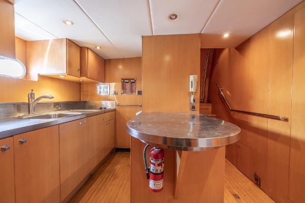 Modern kitchen interior of 2001 Grand Harbour 76 yacht with wooden cabinetry and stainless steel countertops.