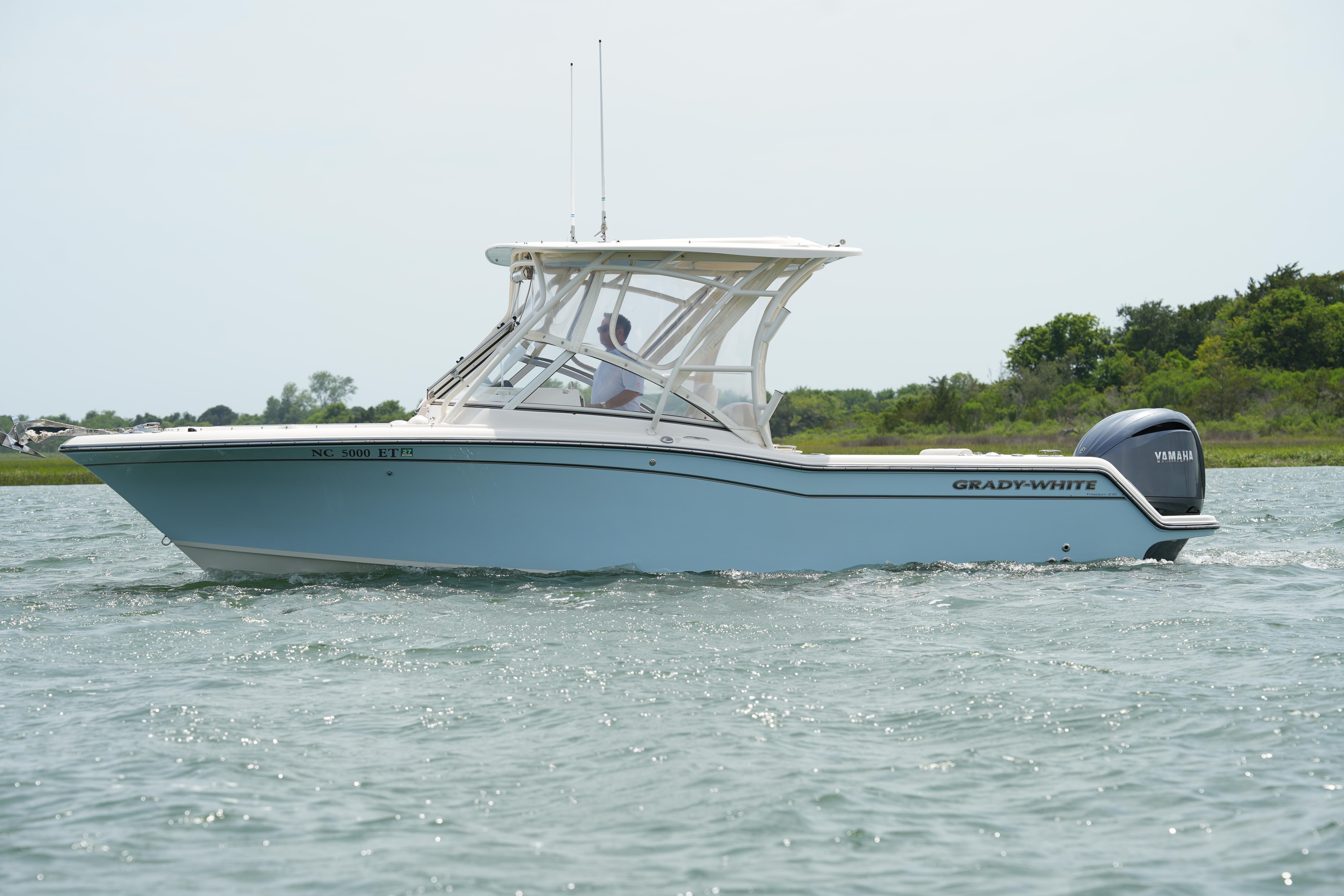 2021 Grady-White Freedom 235 boat cruising on a calm waterway.