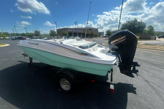 2026 Tahoe T16 boat with Mercury engine on trailer, parked outdoors under blue sky.