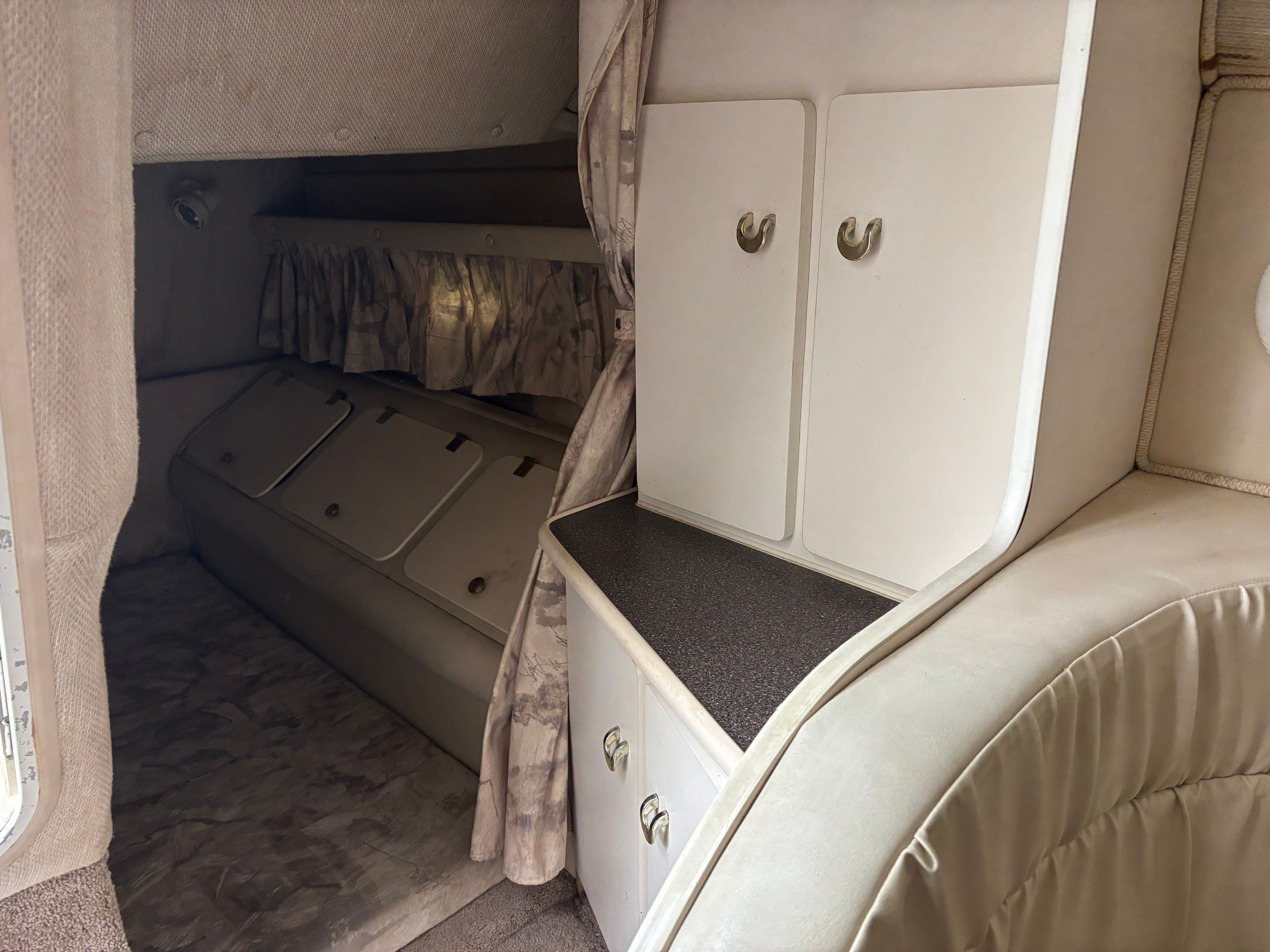 Interior of a Rinker Fiesta Vee 280 with sleeping area and cabinets.