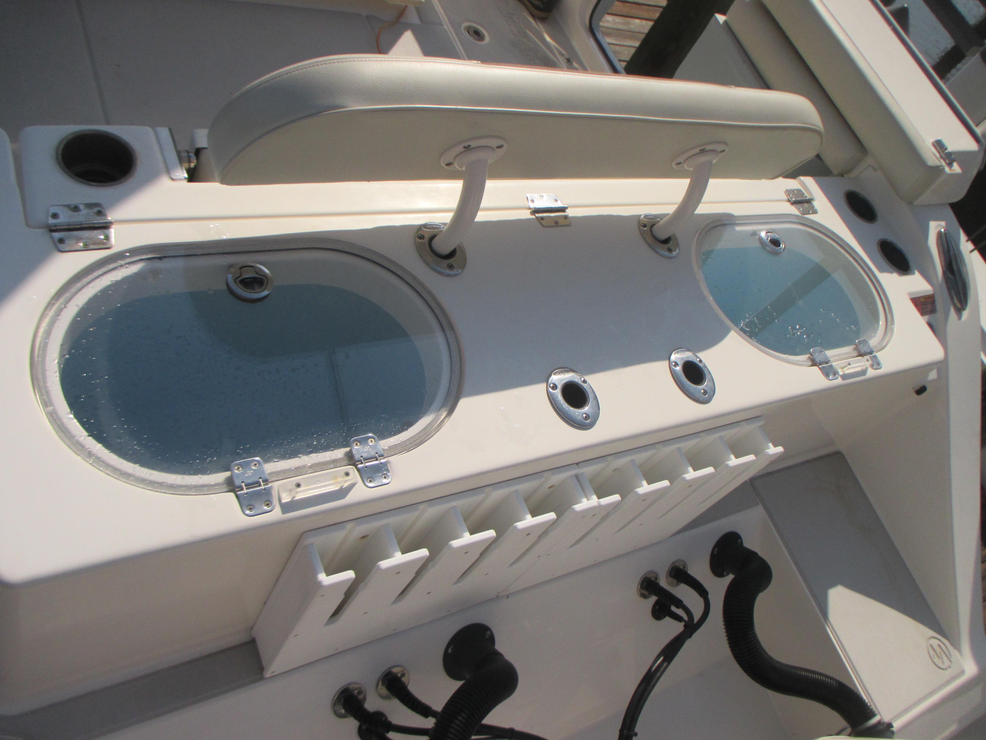2018 Cobia 301 Center Console boat with dual livewells and rod holders.