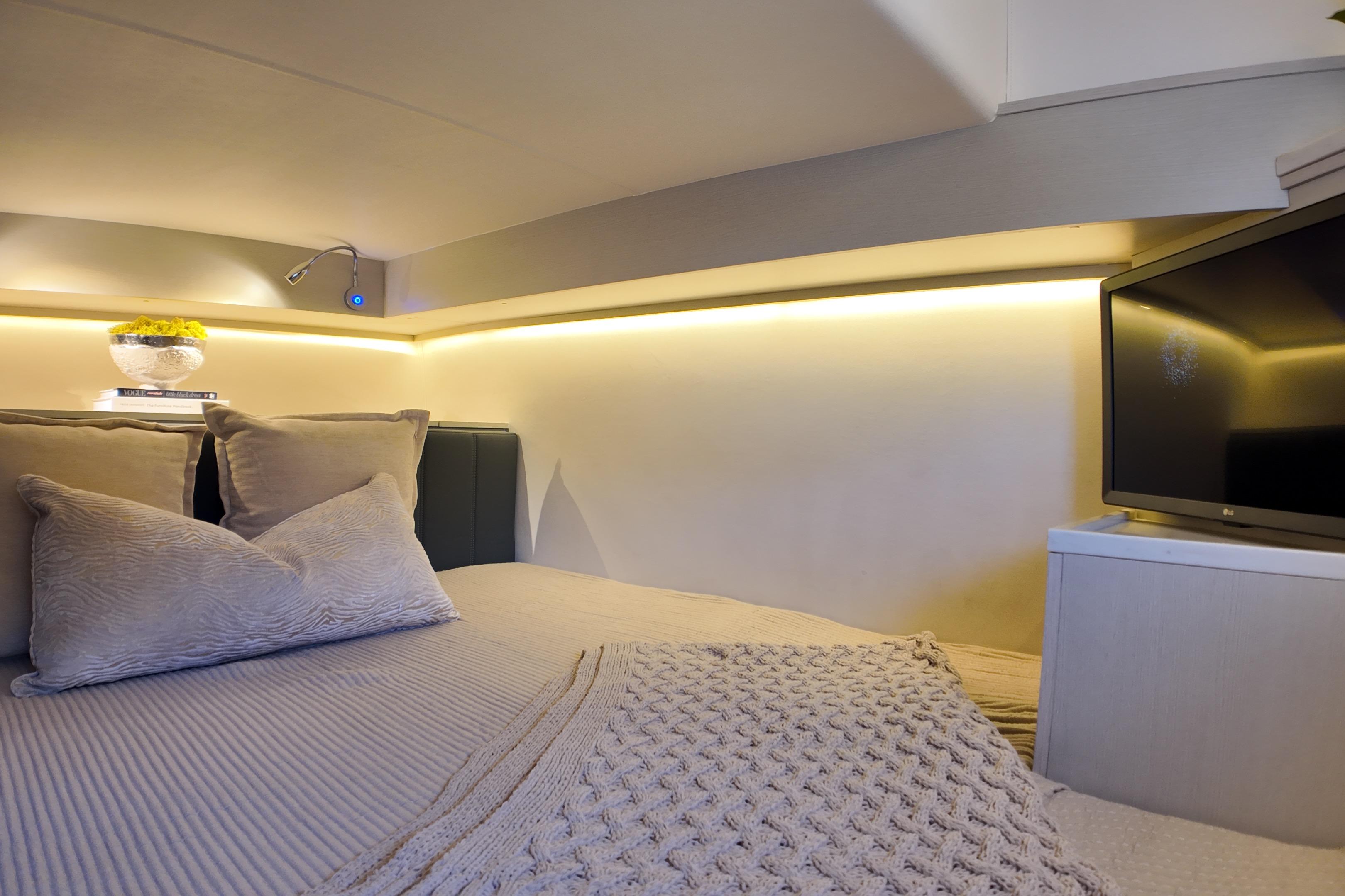 Luxurious interior of 2025 Valiatt 350GT with cozy bedding and modern TV setup.