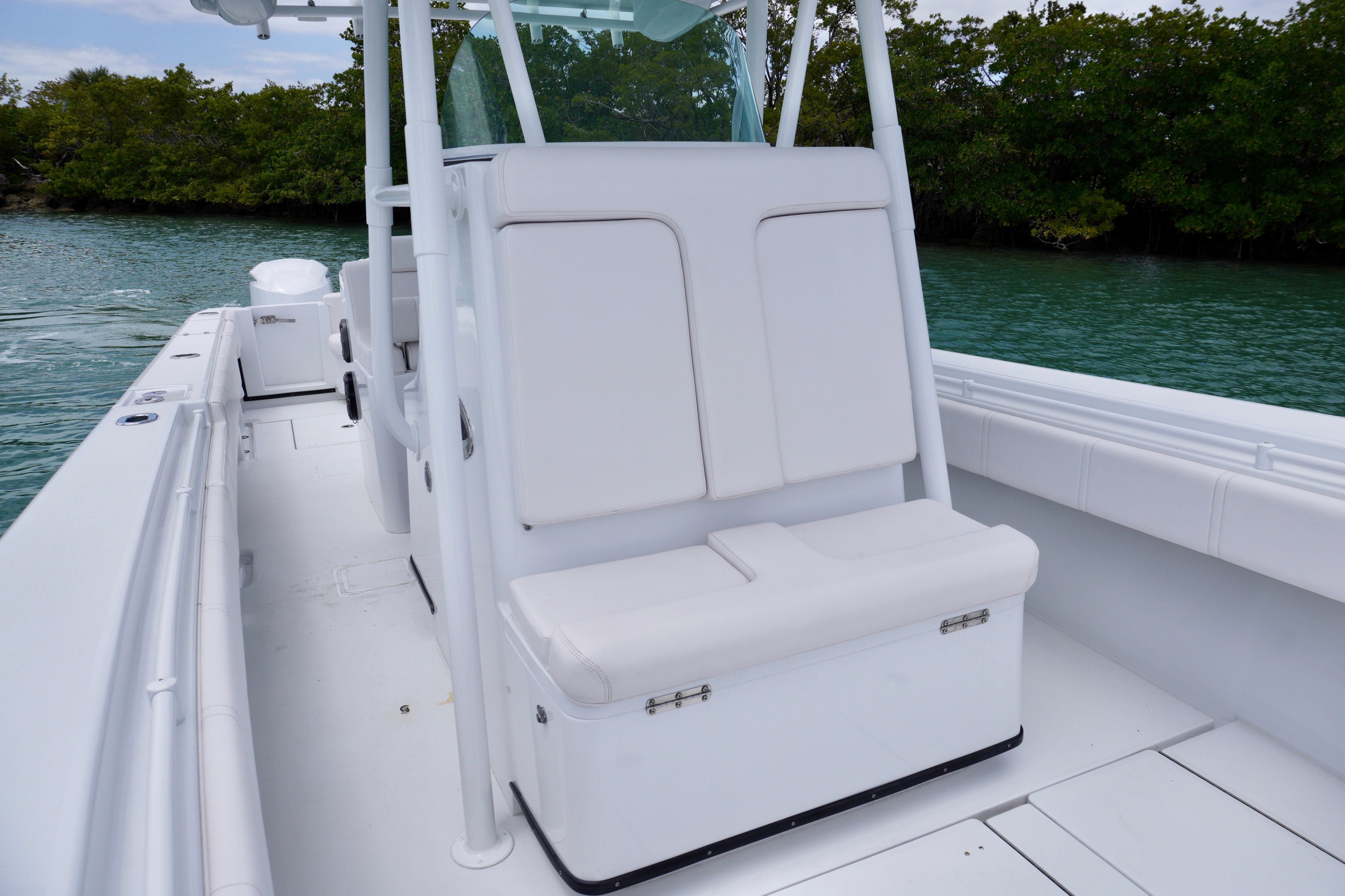 2013 Contender 35 LS boat interior with white seating, on calm water near lush greenery.