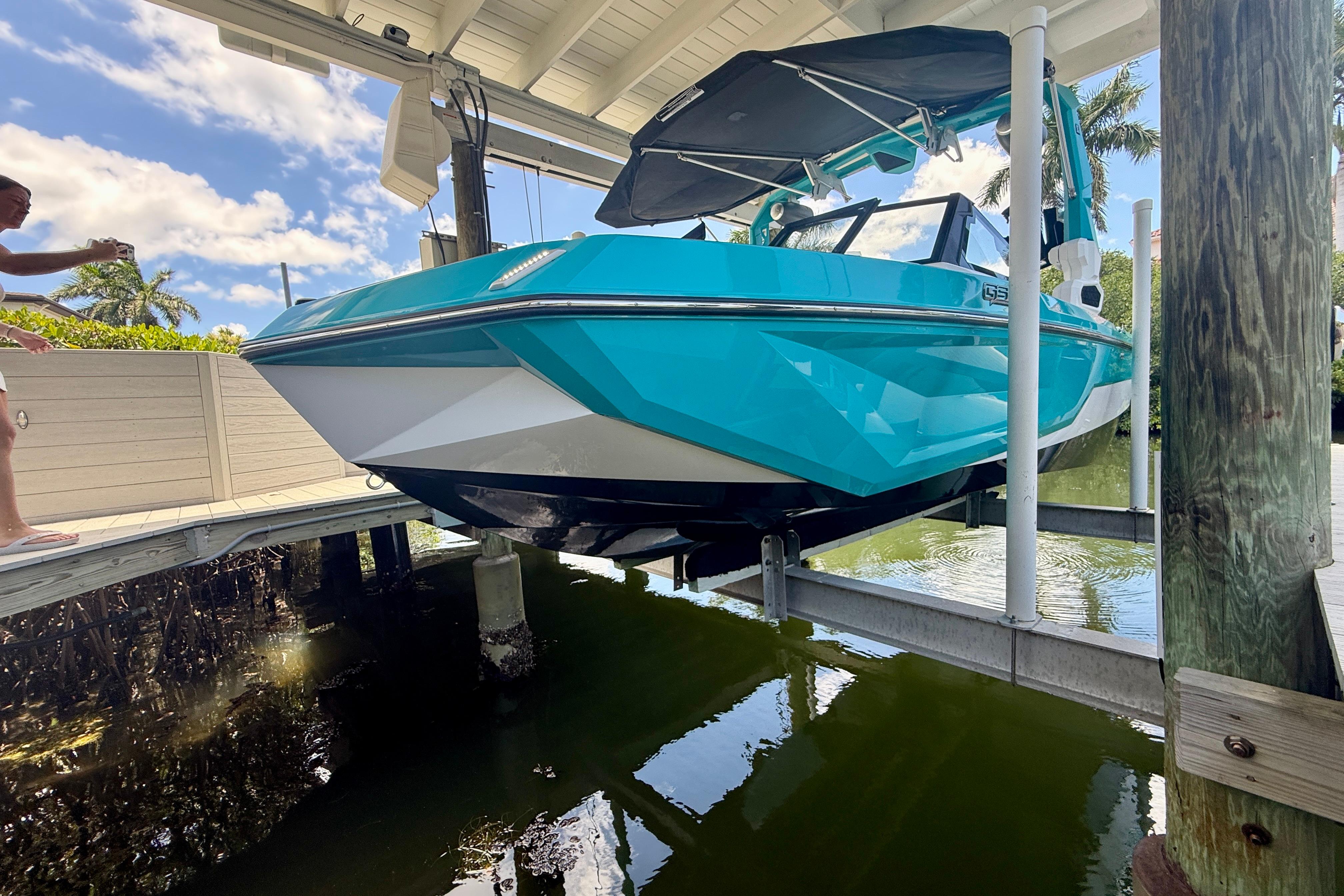 2024 Nautique Super Air Nautique GS20 boat on lift, vibrant blue color, sunny day.