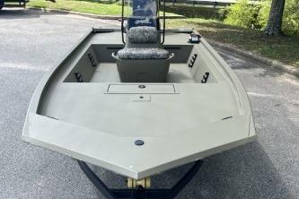 2026 Tracker Grizzly 1860 CC boat, parked on pavement, showcasing spacious deck and seating.