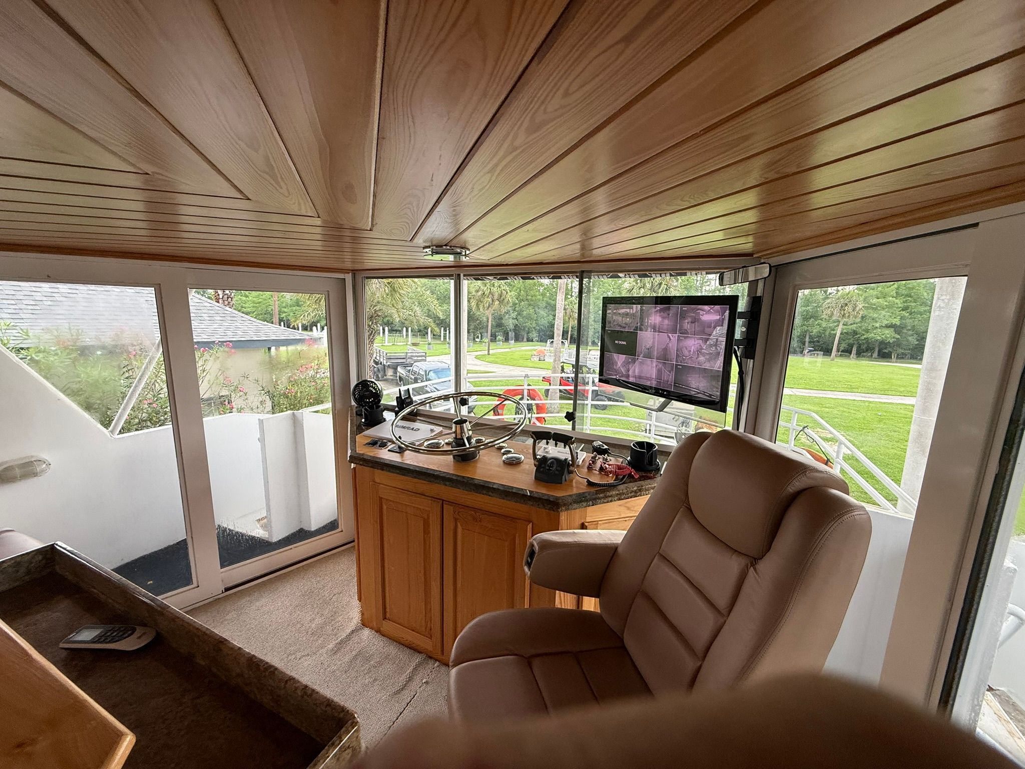The image shows a boat's helm with a comfortable seat and a monitor.