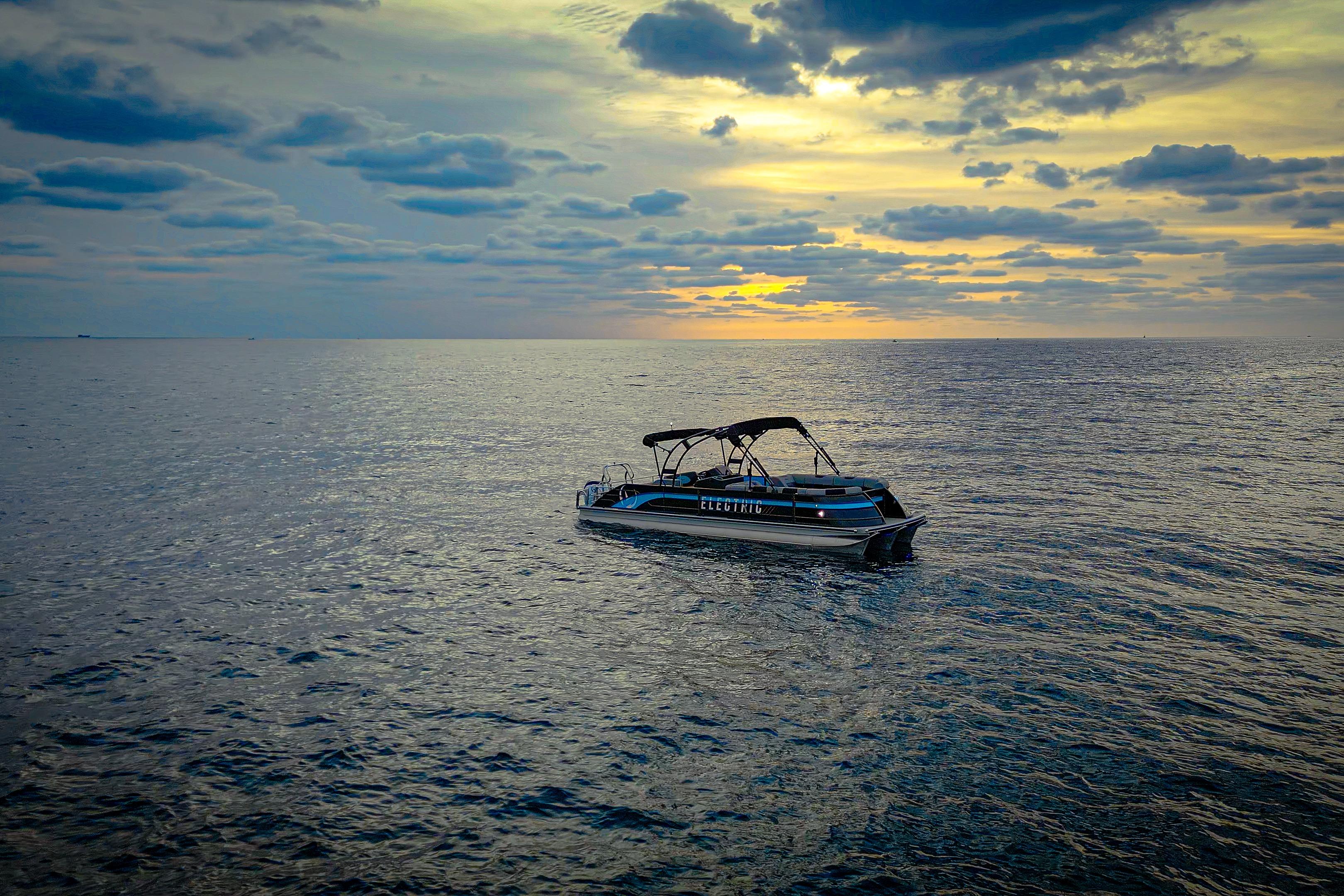 Electric Vision Marine Technologies V30 boat on serene ocean at sunset, 2025 model.
