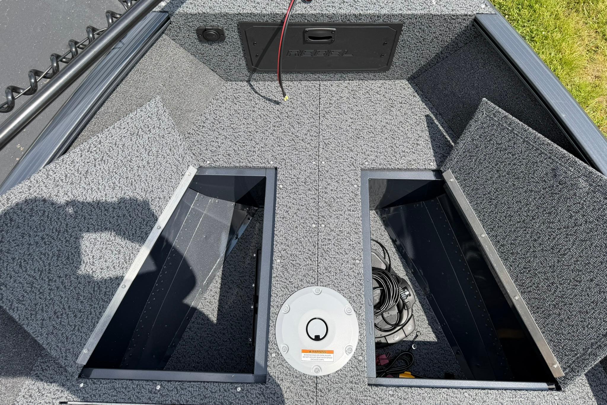 2027 Lund 1650 Rebel XL SS boat interior with storage compartments and carpeted flooring.