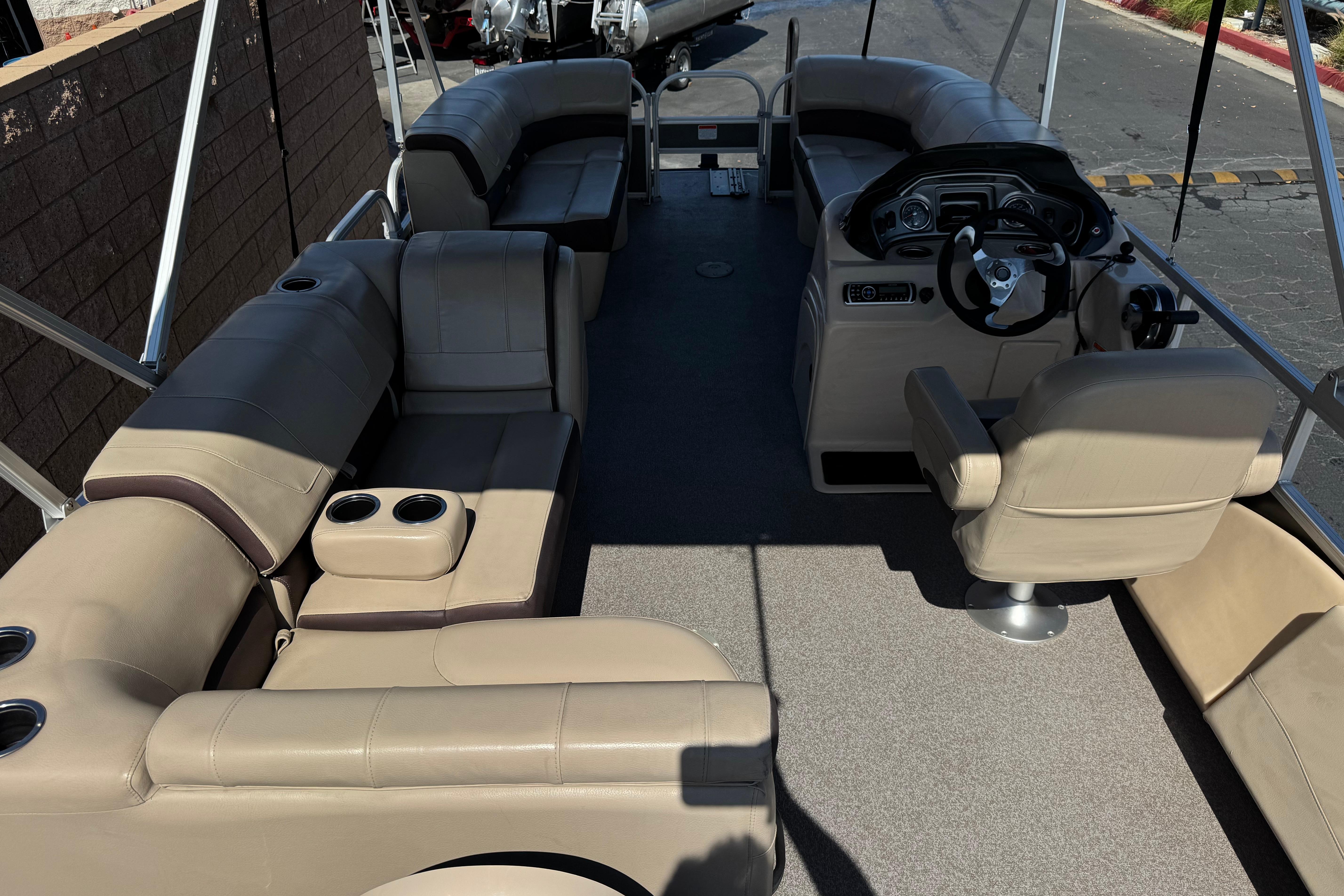 2018 Sun Tracker SportFish 22 DLX pontoon boat interior with beige seating and steering console.