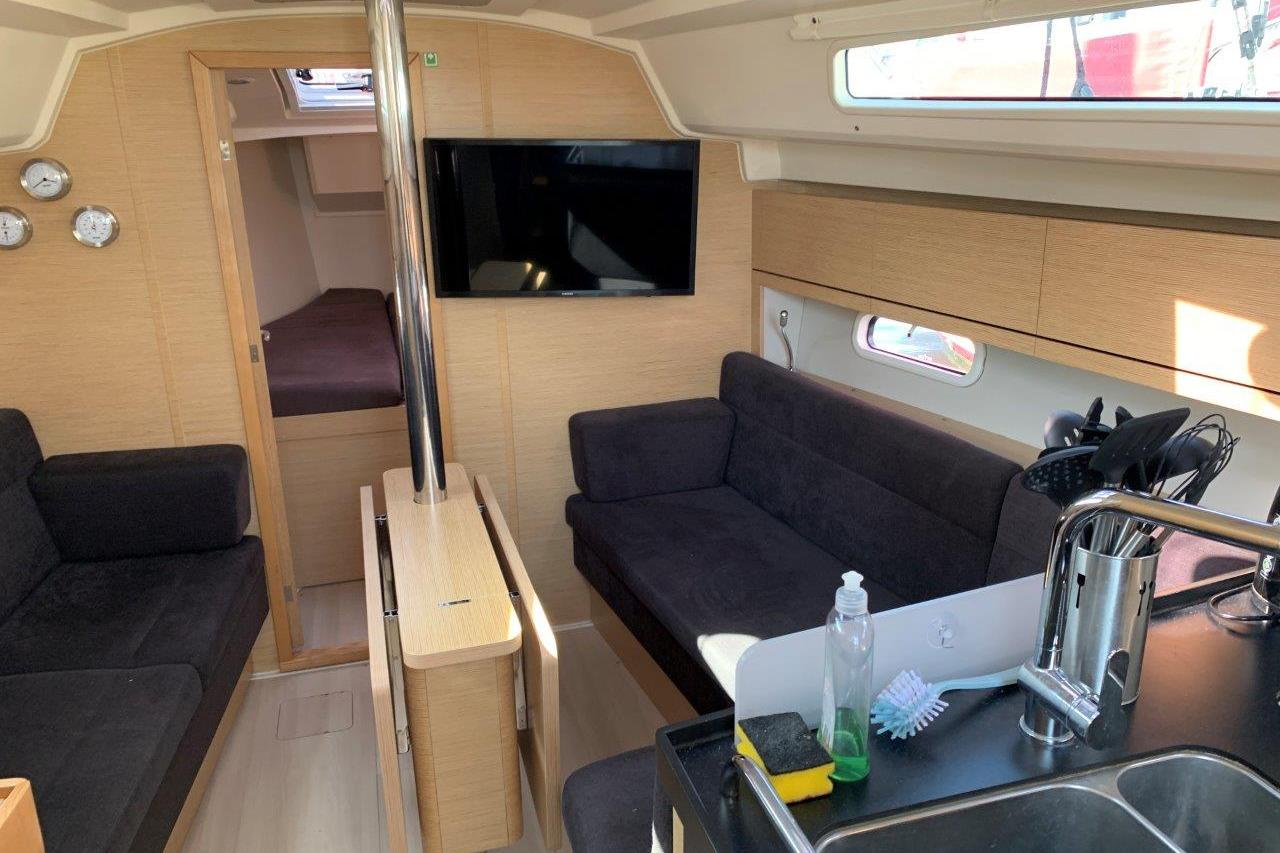 Interior of 2022 Hanse 348 yacht with modern seating and kitchen area.