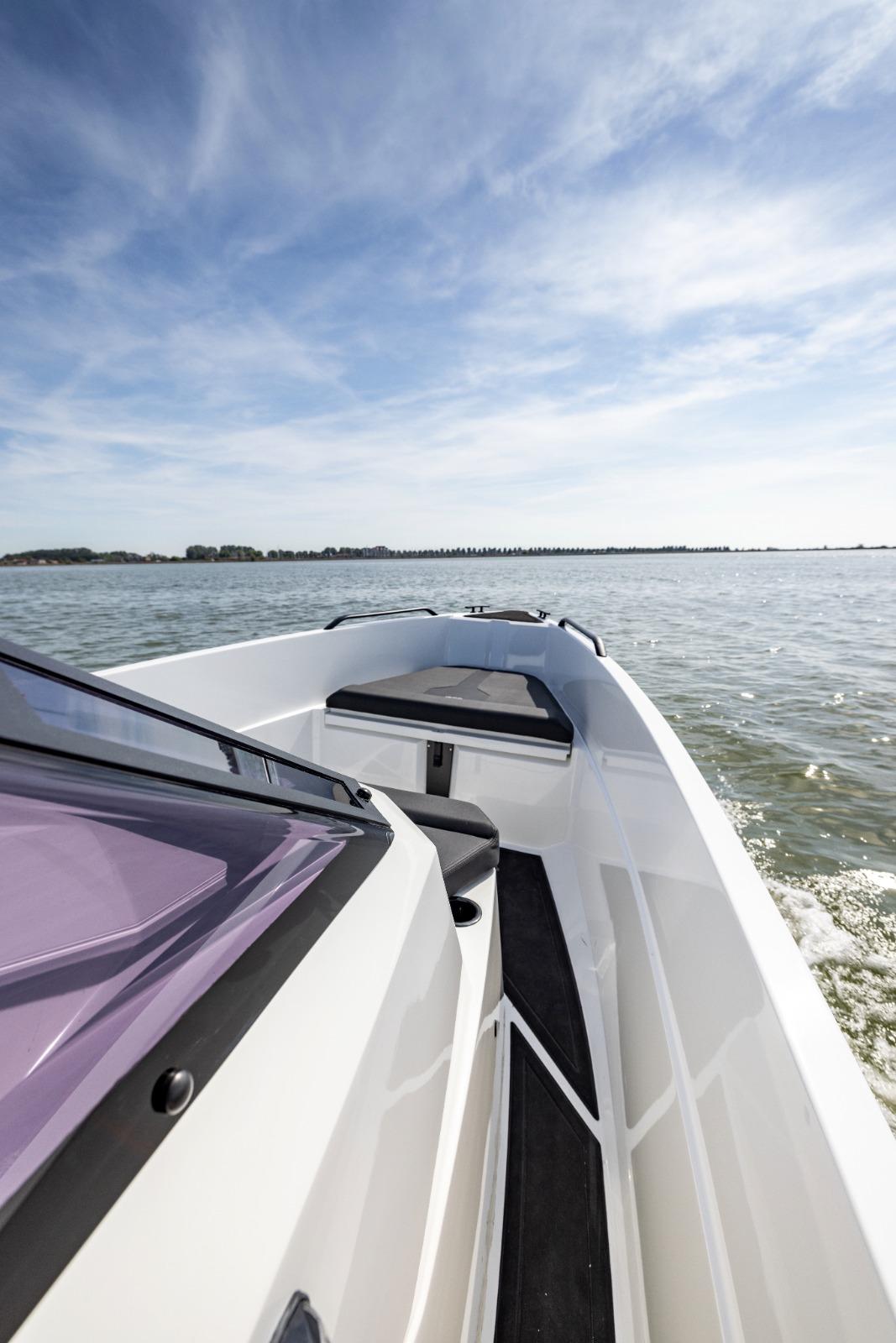 Modern Iron 707 boat cruising on open water under a clear blue sky, 2022 model.