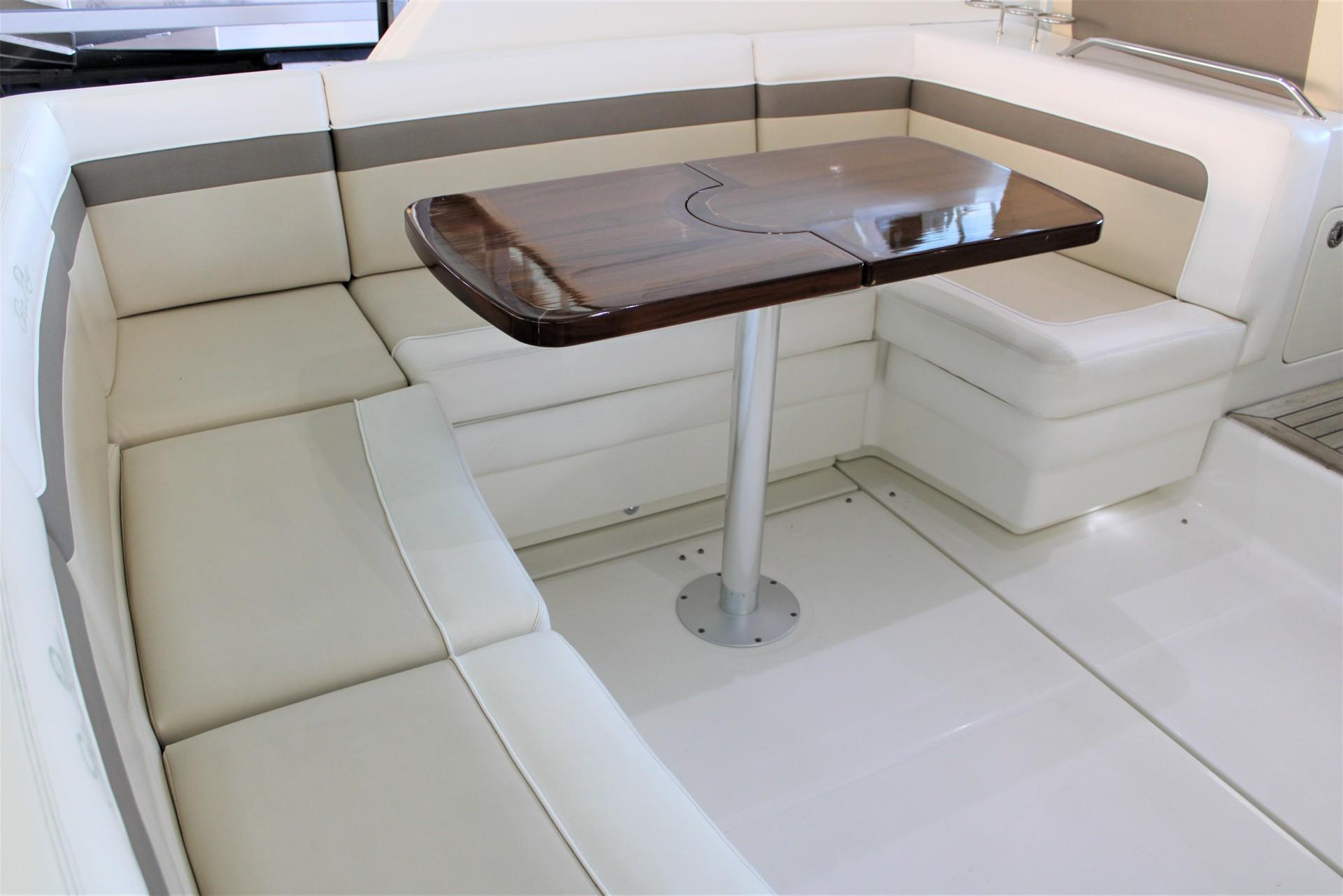 Luxurious seating area on 2012 Sea Ray 450 Sundancer yacht with wooden table.