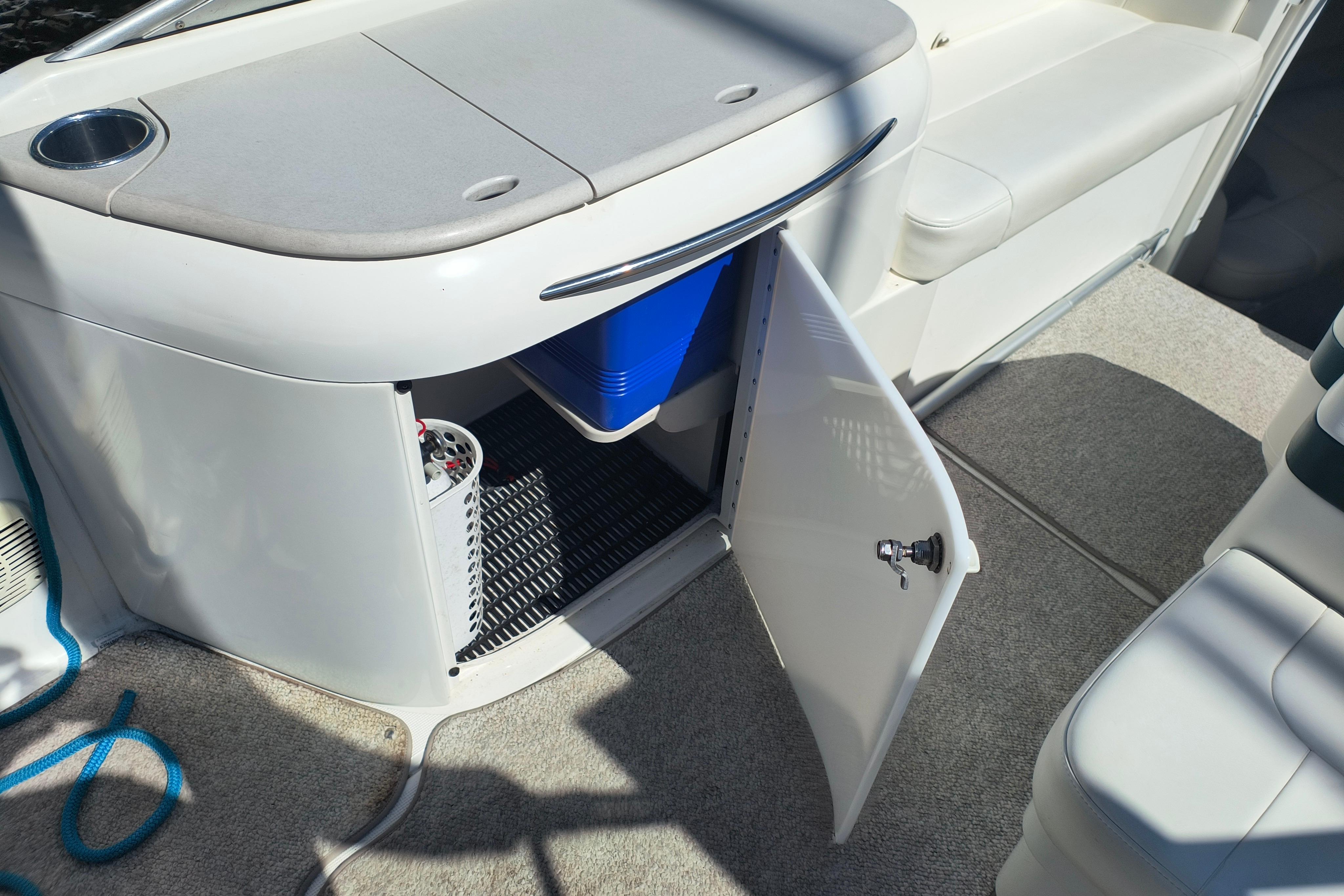 2003 Formula 260 Sun Sport boat interior with open storage compartment and blue cooler.