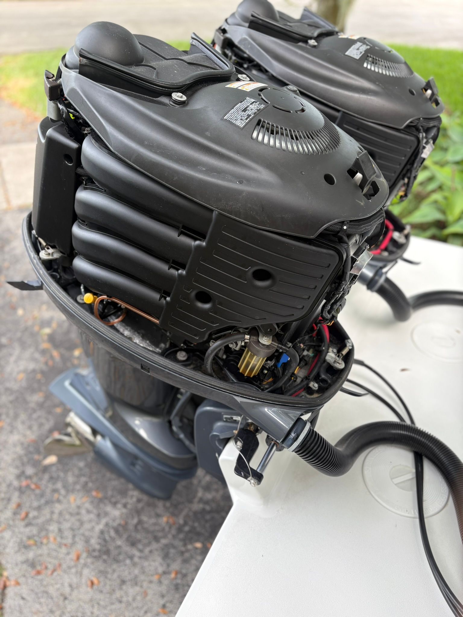 Two outboard motors with open covers reveal their internal components.