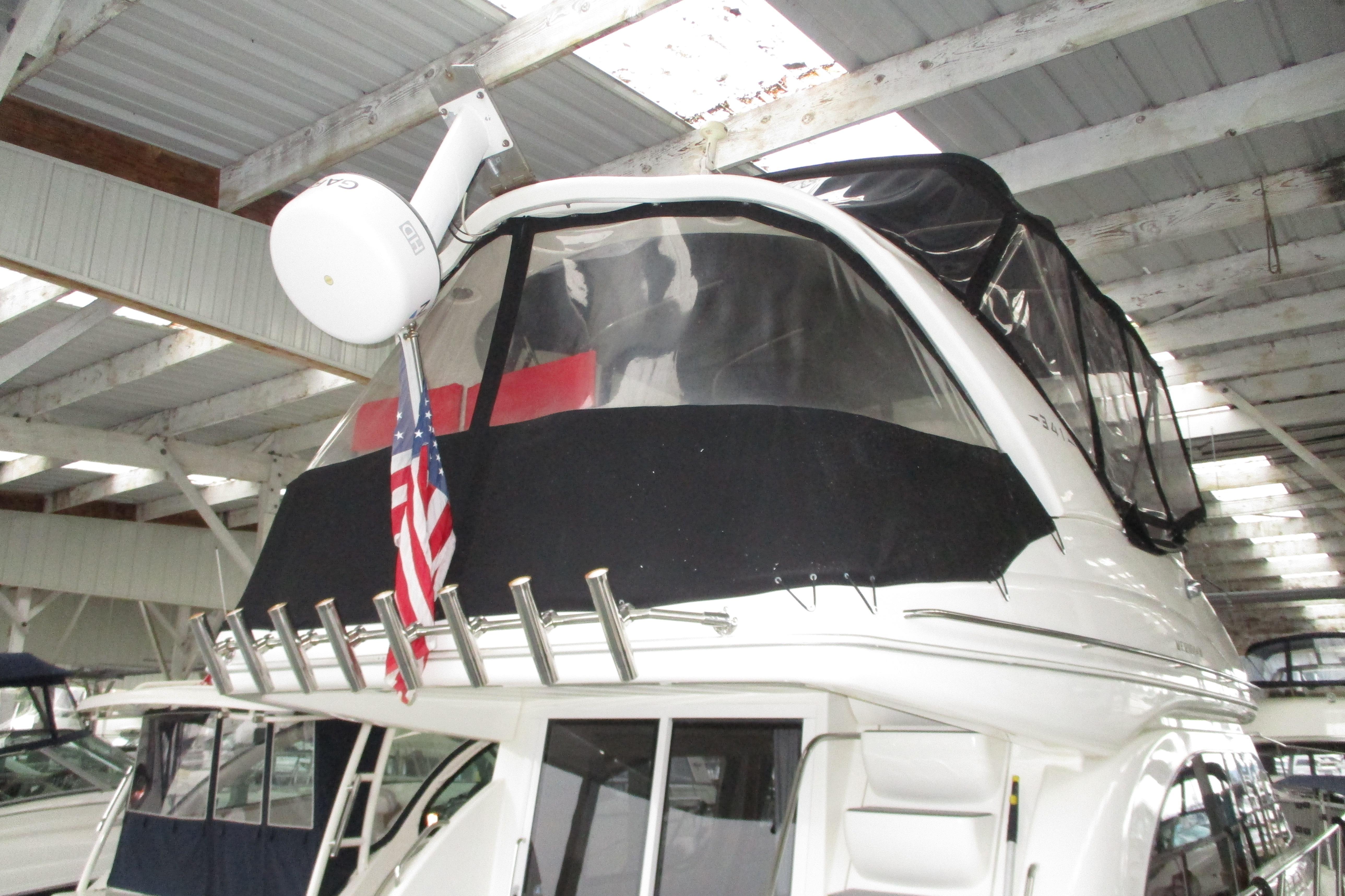 2004 Meridian 340 yacht with radar and American flag in covered marina.