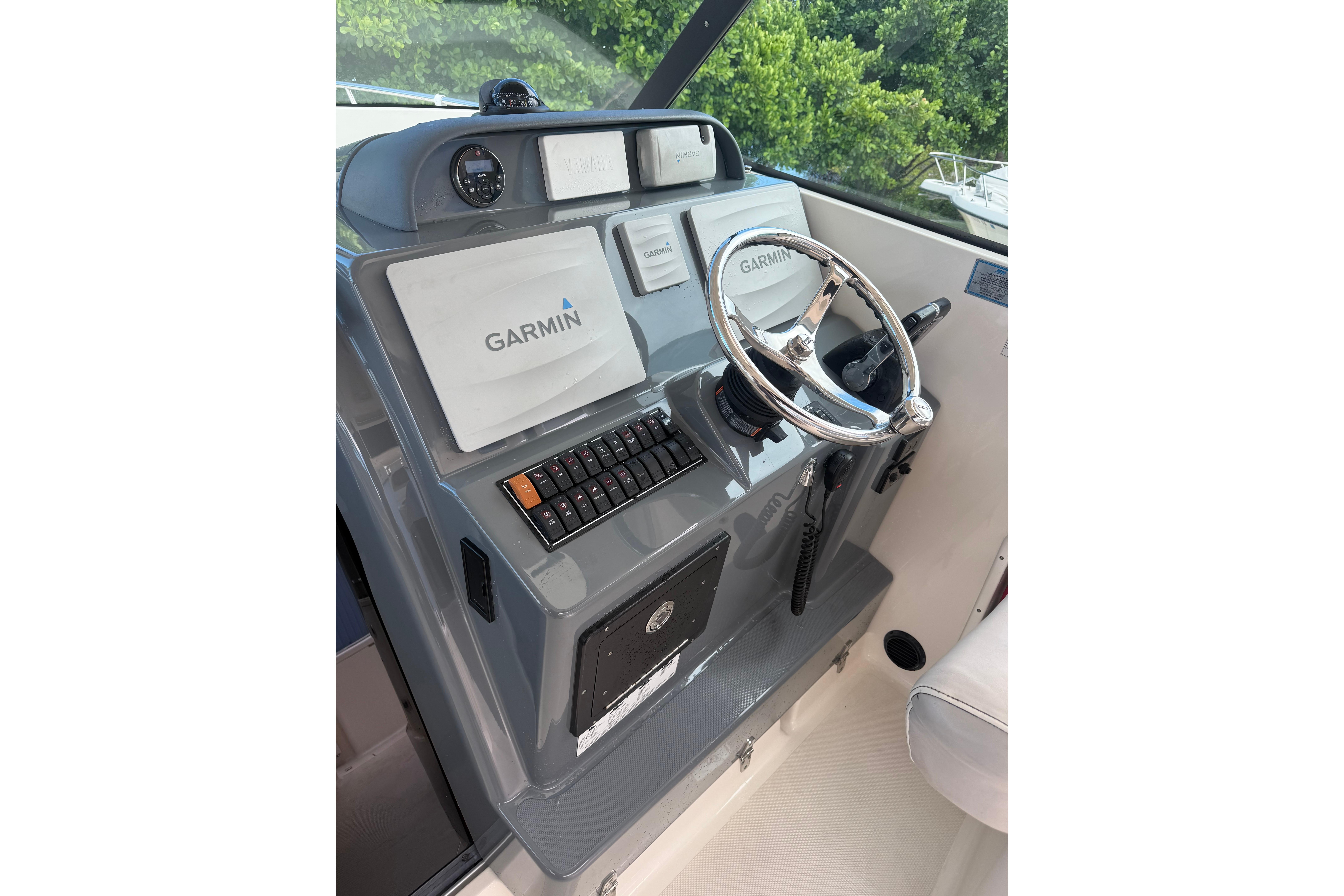 Helm of 2014 Pursuit OS 345 Offshore with Garmin navigation system and steering wheel.