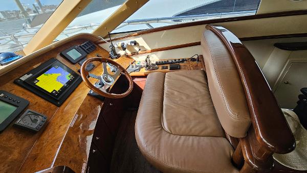 Luxurious 2005 Neptunus 56 Flybridge yacht helm with leather seating and navigation equipment.