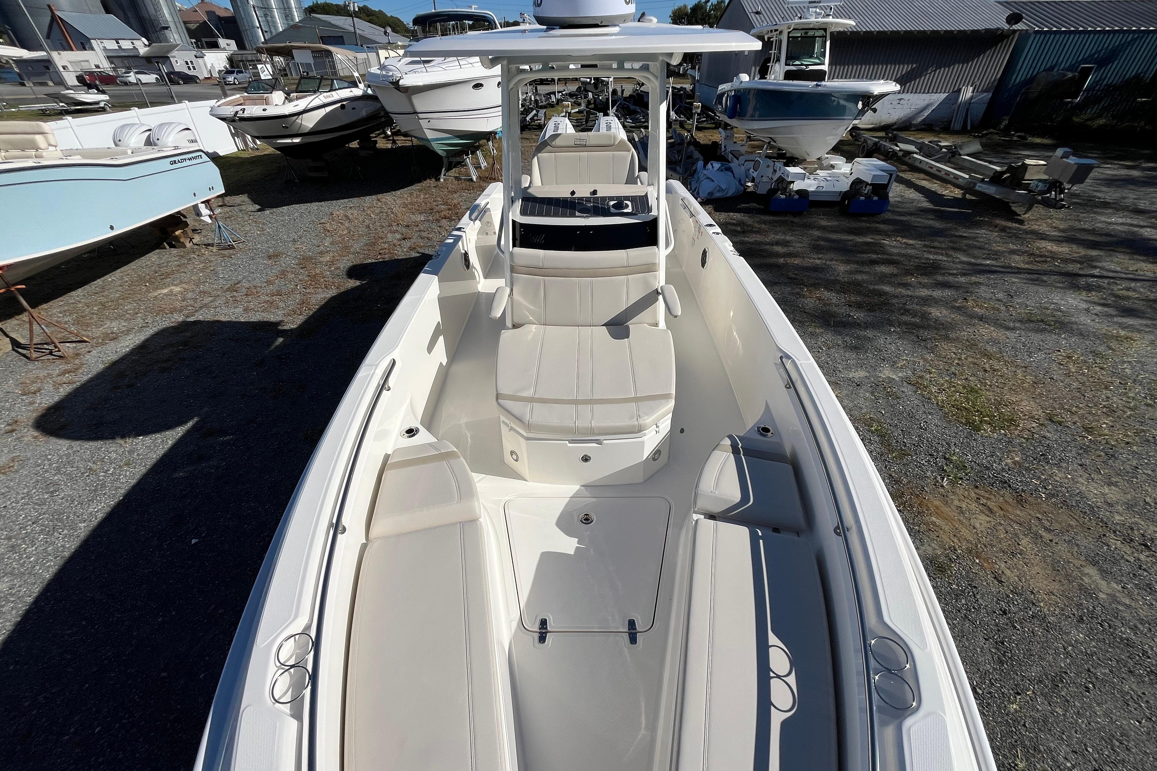 2026 Boston Whaler 280 Dauntless boat, docked, showcasing spacious seating and sleek design.