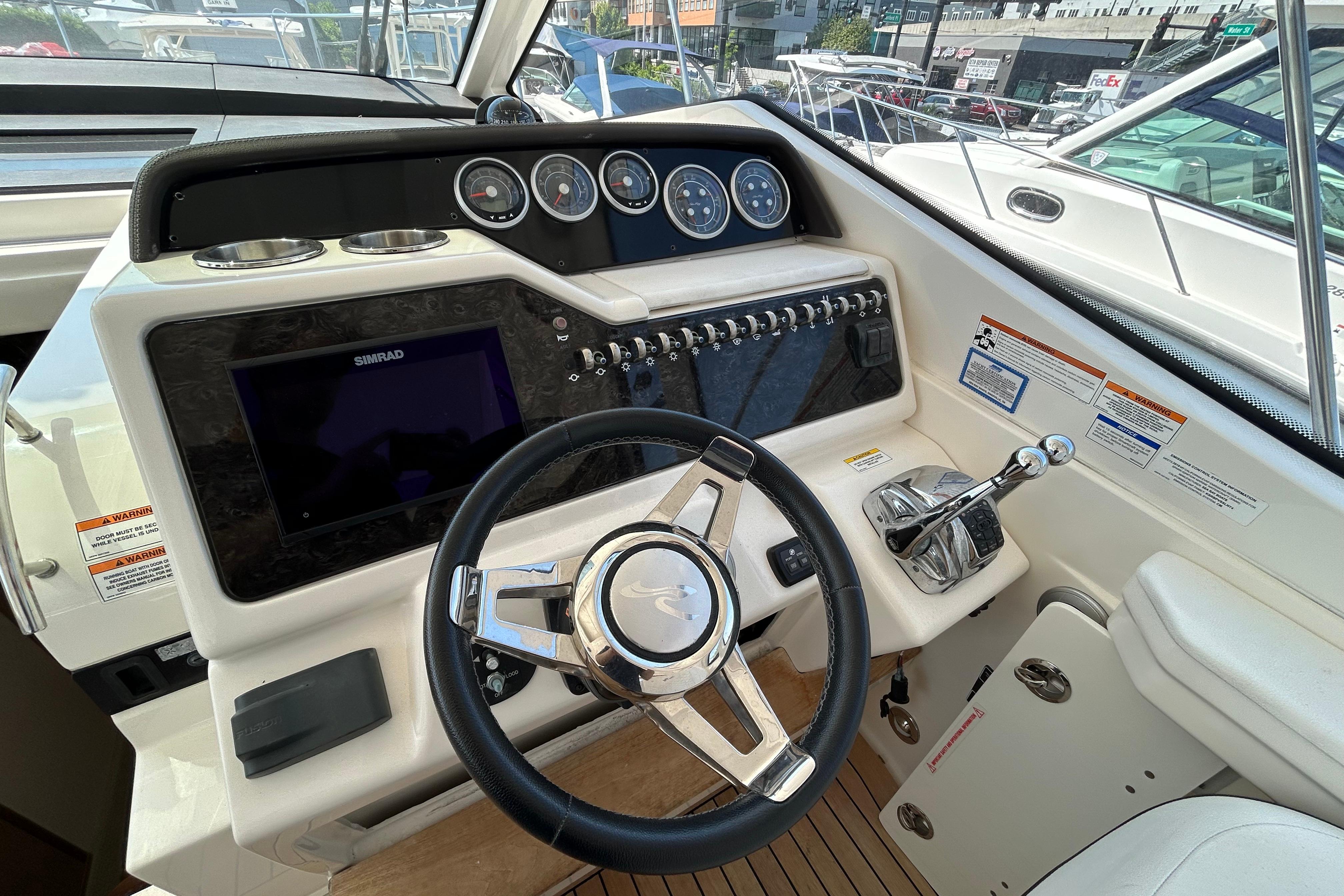 2019 Sea Ray Sundancer 350 helm with steering wheel, gauges, and navigation controls.