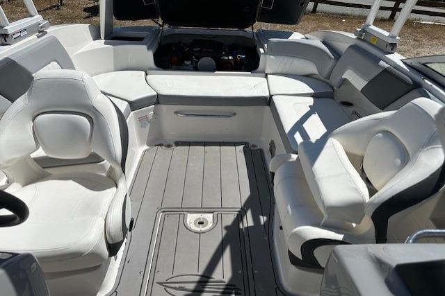 2023 Chaparral 23 SSi boat interior with white seating and open engine compartment.