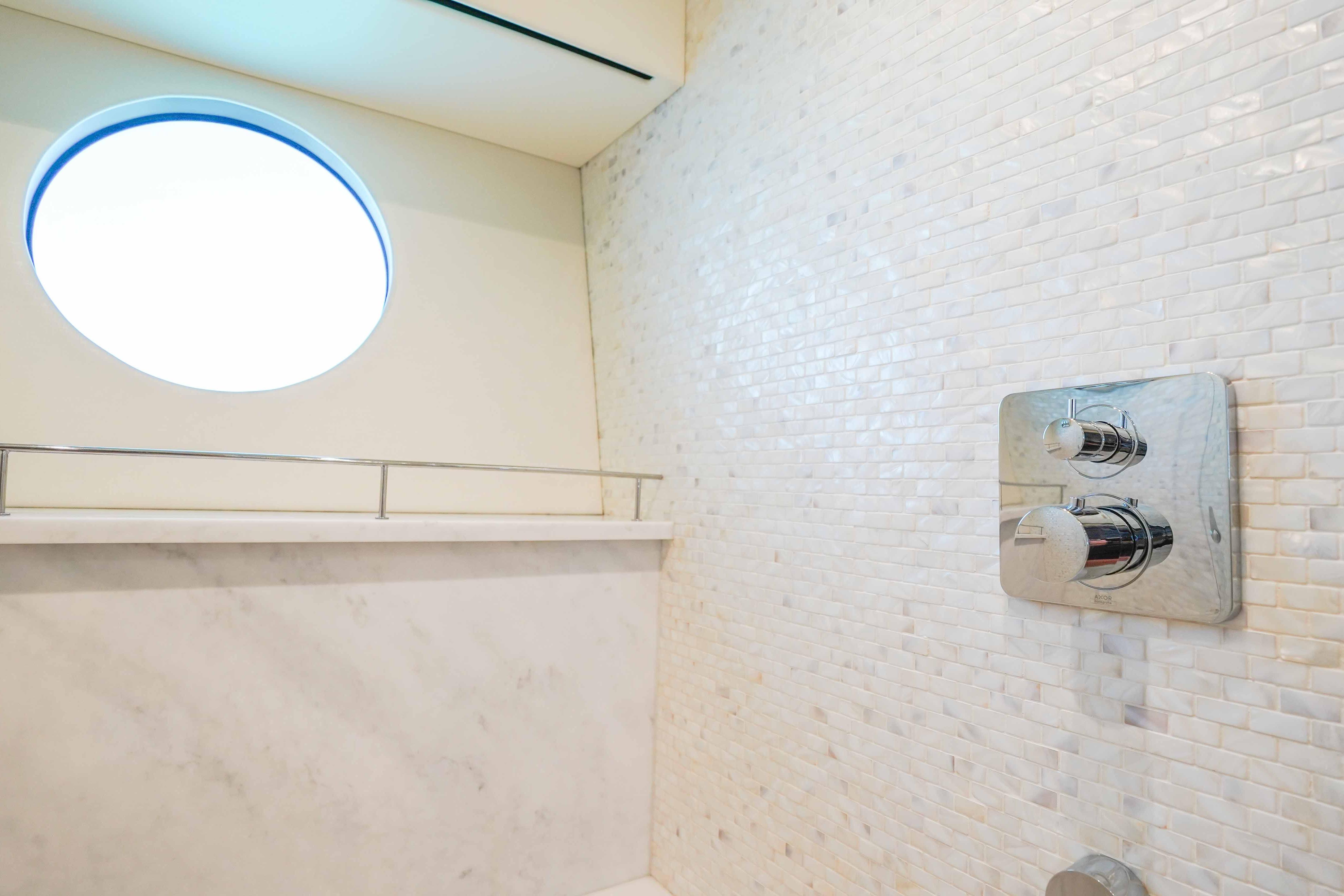 Luxurious bathroom in 2016 Sunseeker 75 Yacht with modern fixtures and porthole window.