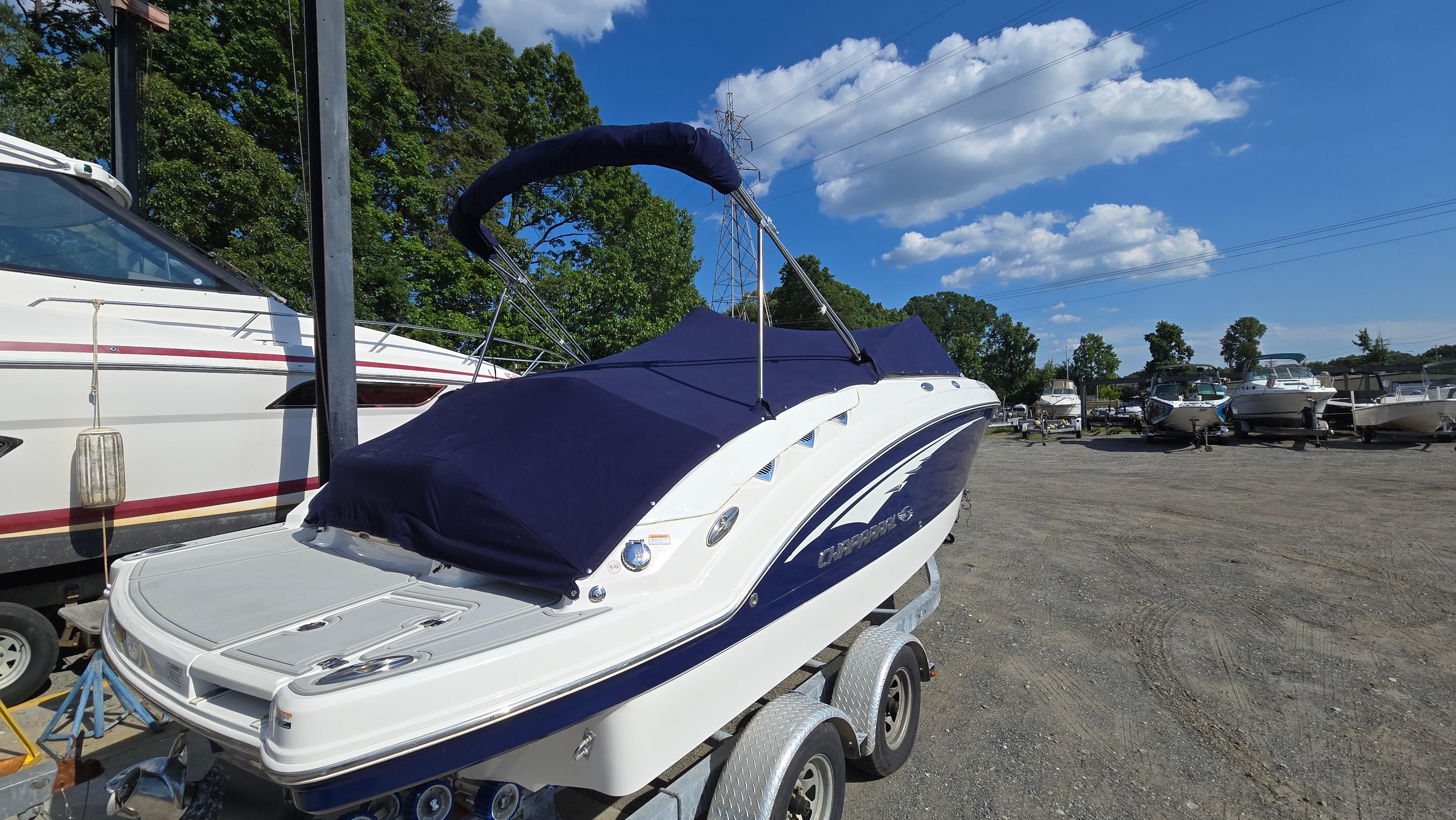 2018 Chaparral 224 Sunesta boat on trailer, covered, in outdoor storage area.