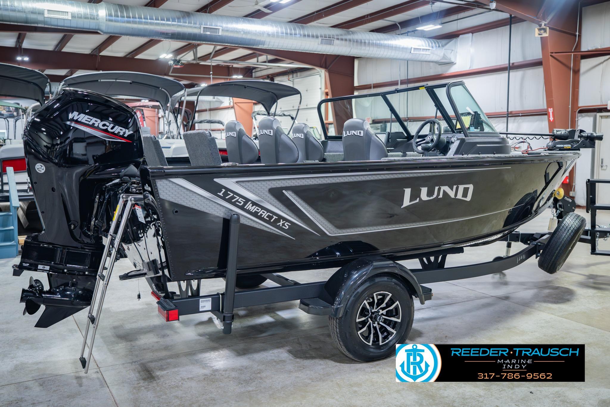 2026 Lund 1775 Impact XS boat with Mercury engine in showroom setting.