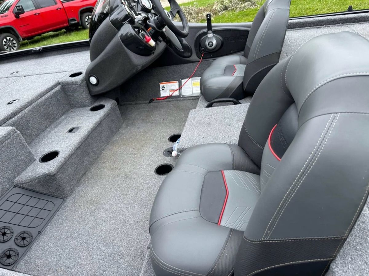 The image shows the cockpit of a 2022 Bass Tracker 195TXW with gray seats and a steering console.