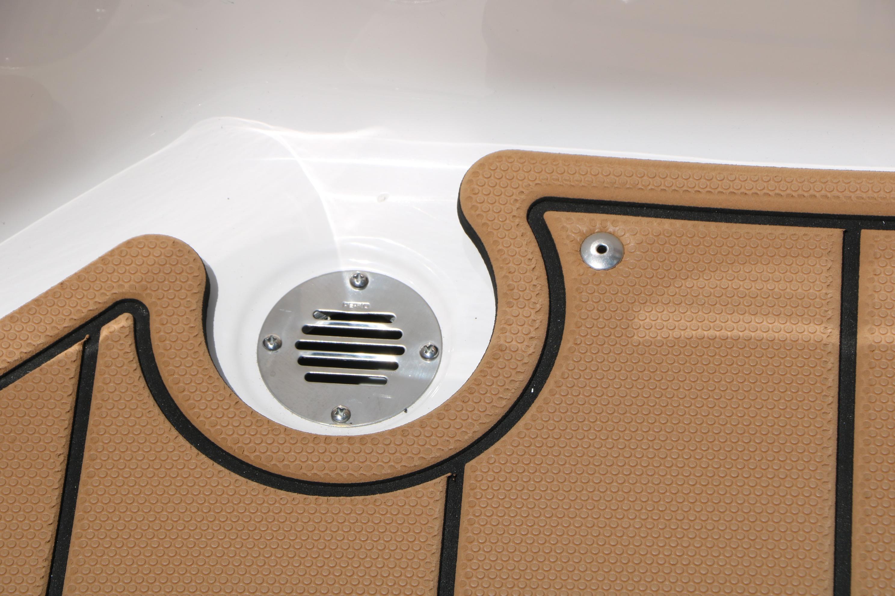 2025 Chaparral 23 SSi boat deck with tan non-slip surface and metal drain.