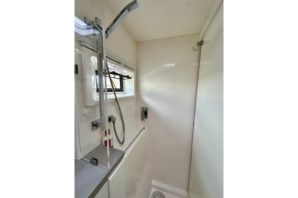 Modern shower area in a 2017 Leopard 40 catamaran, featuring sleek fixtures and a window.