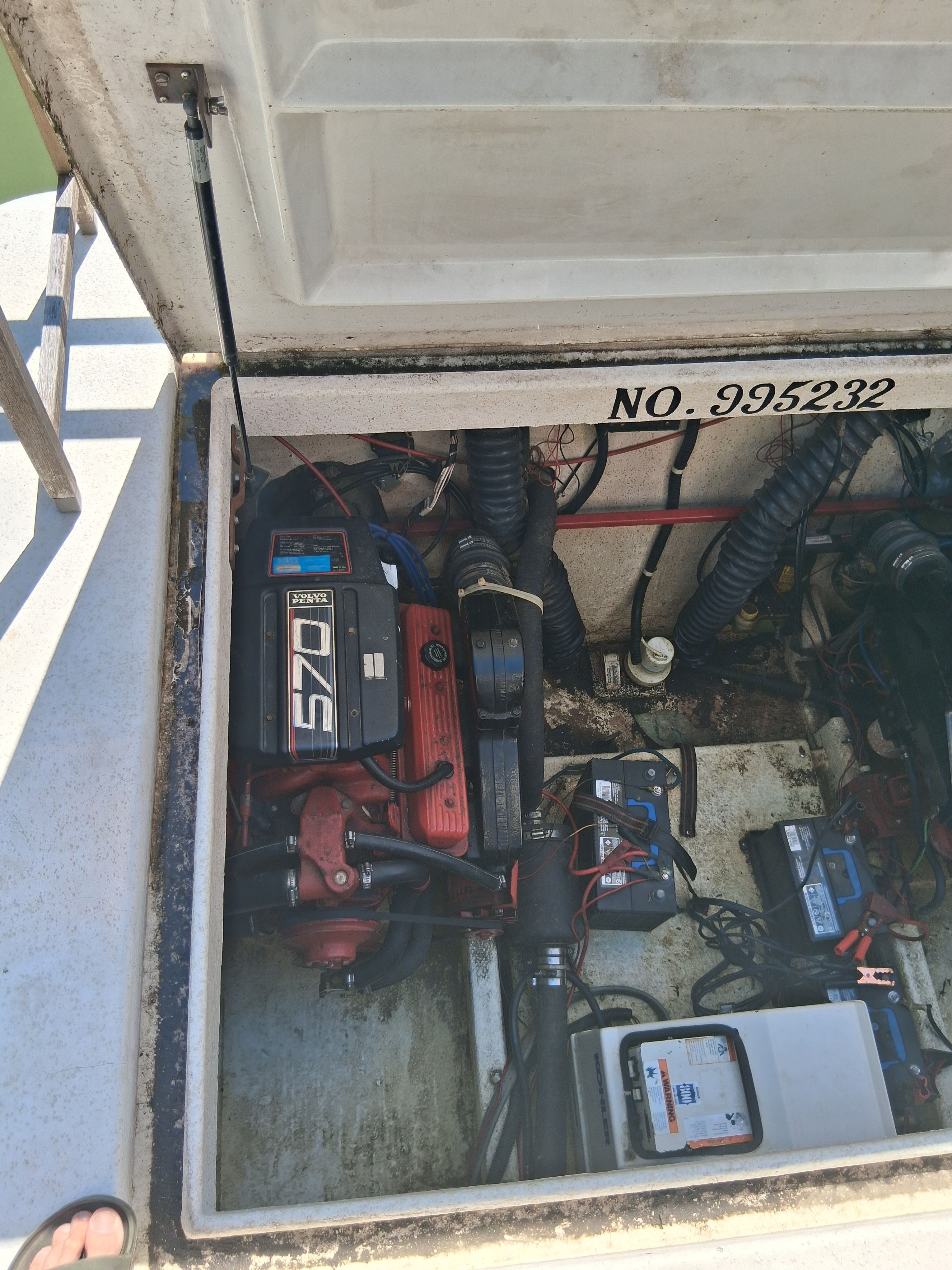 An engine compartment with a Volvo Penta 570 engine and several batteries.