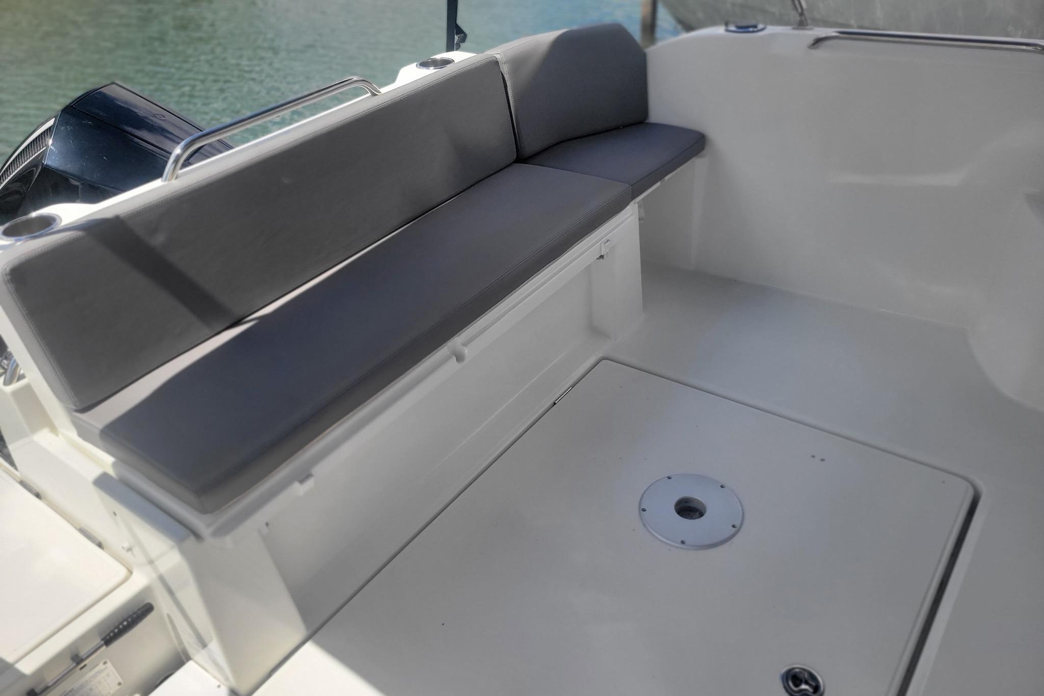 2019 Beneteau Antares 23 boat interior with cushioned seating and sleek design.