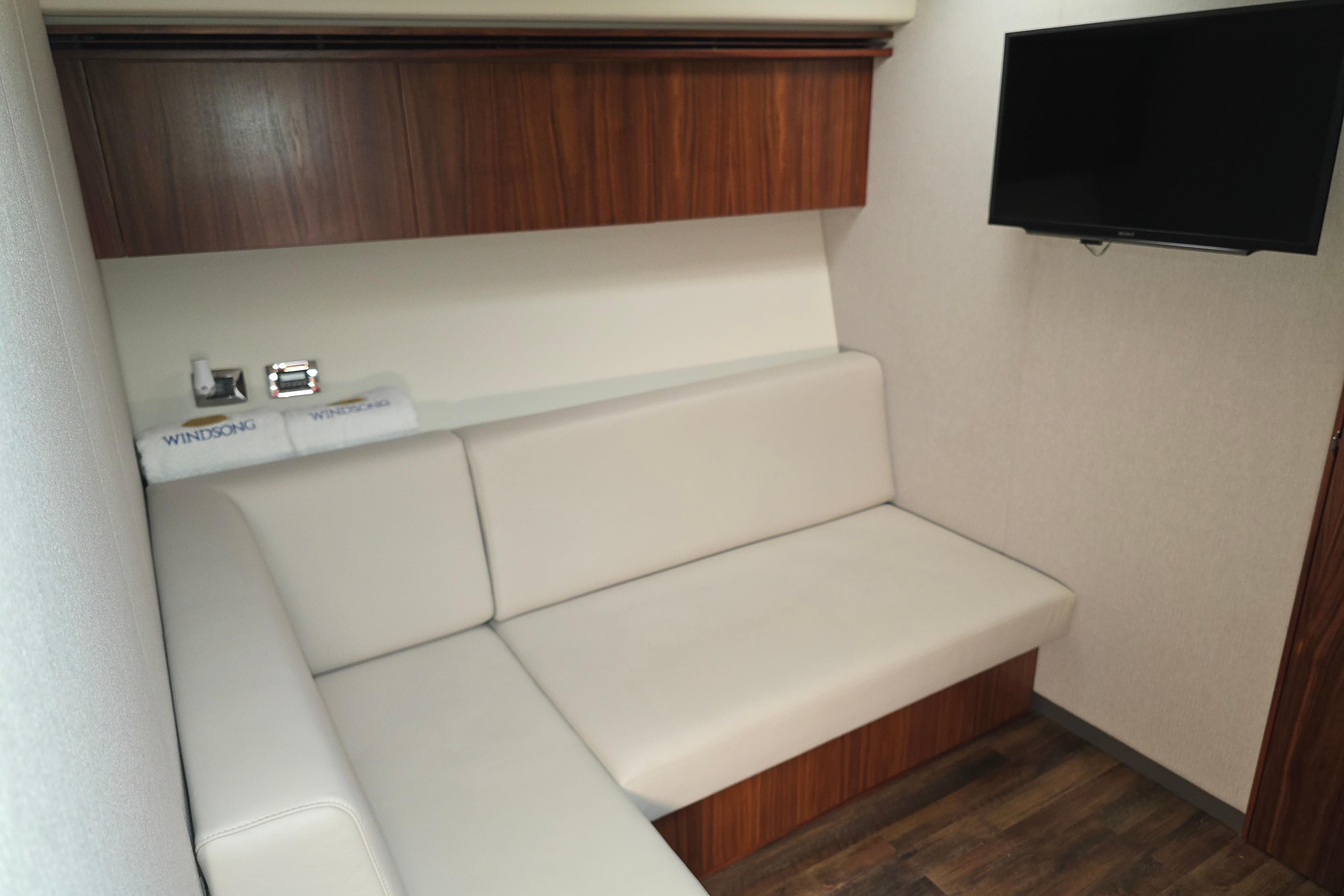 2019 Riviera 5400 Sport Yacht interior with beige seating and wall-mounted TV.