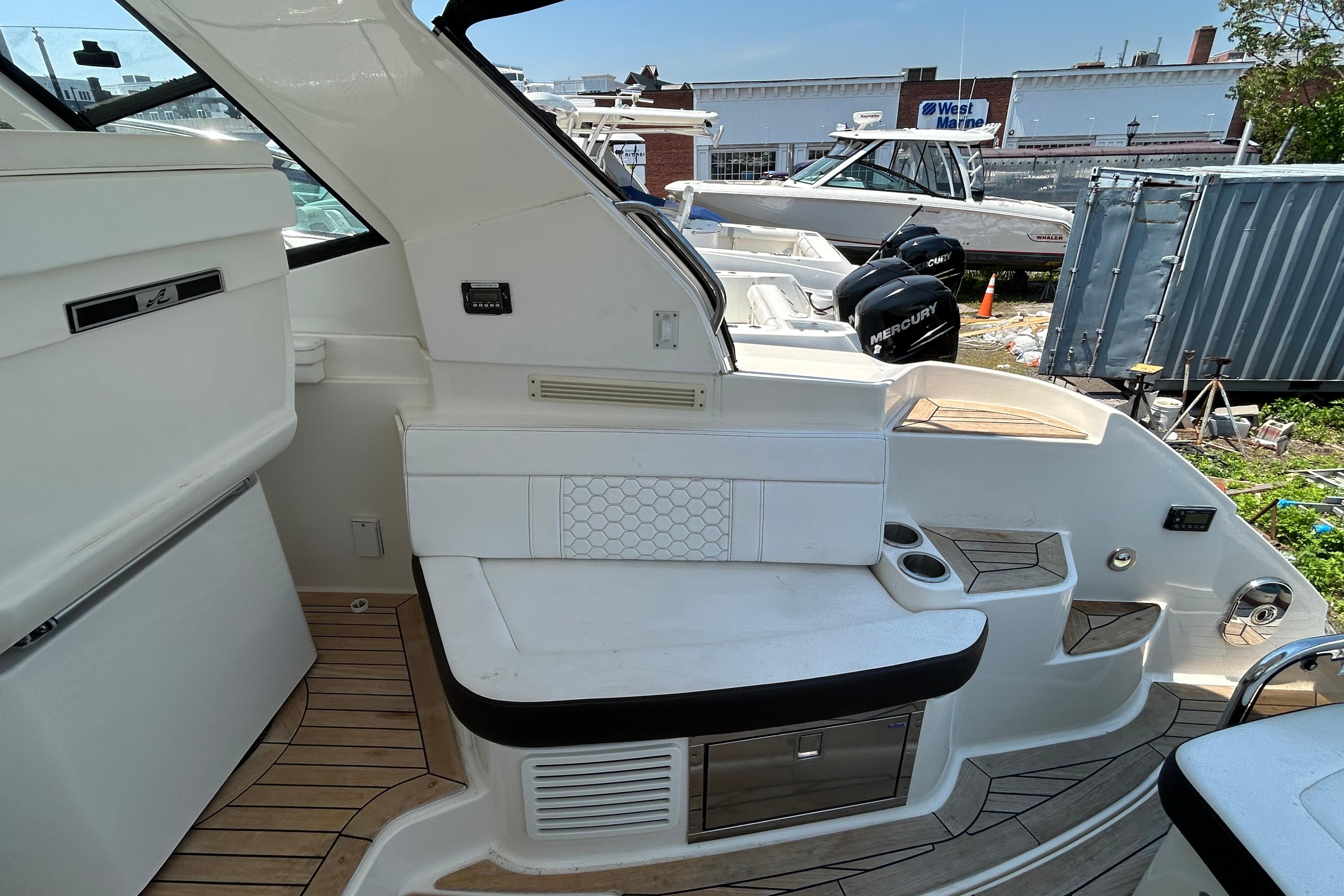 2019 Sea Ray Sundancer 350 yacht interior with seating and storage, docked near other boats.