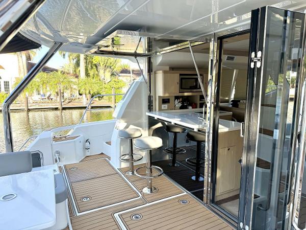 Aquila 44 yacht interior, 2022 model, featuring modern kitchen and seating area by the water.