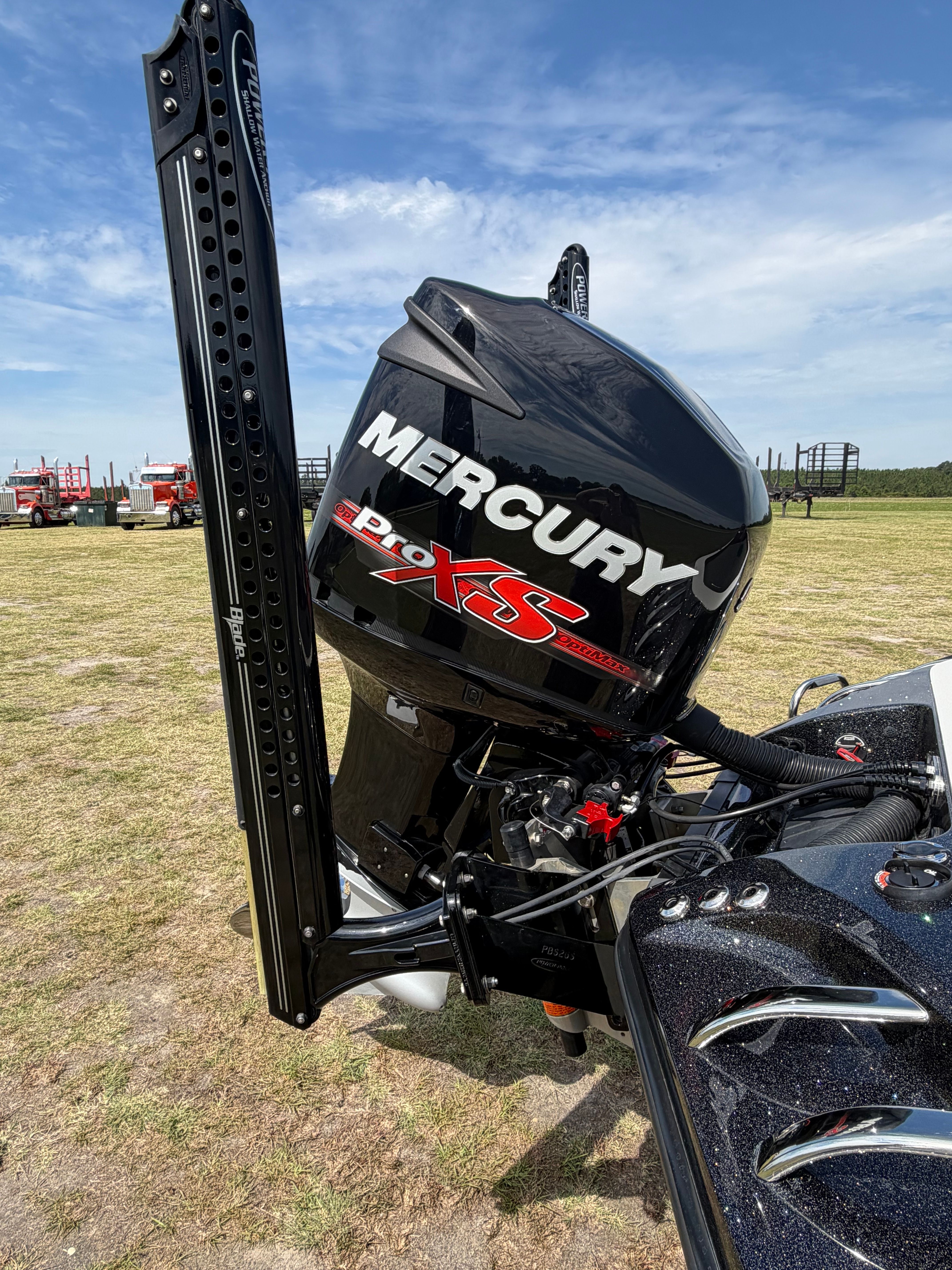 A Mercury Pro XS outboard motor on a Ranger boat on dry grass.