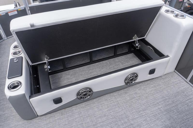 Open storage compartment on 2026 SunCatcher Elite 326 SL boat with cup holders and speakers.